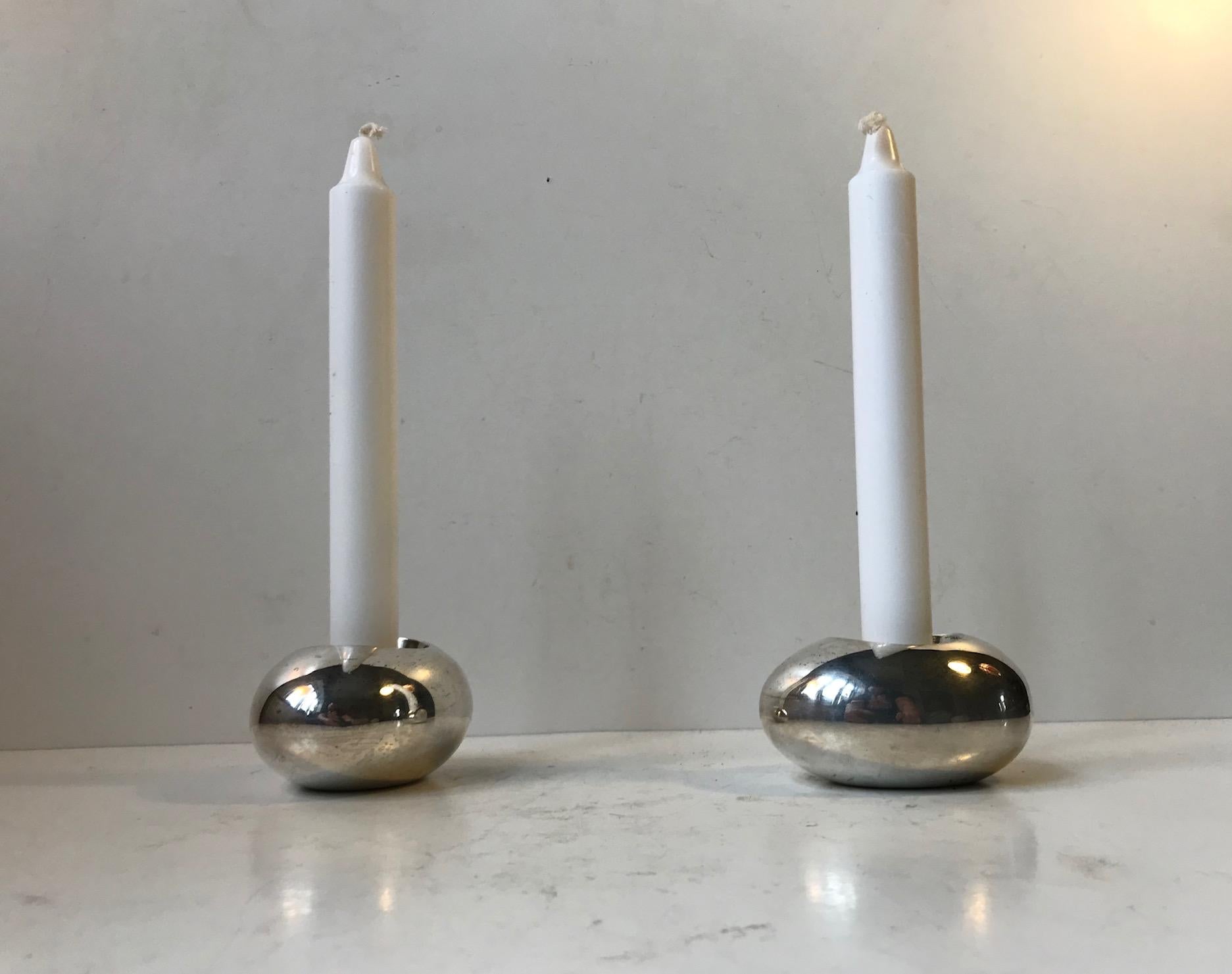 A pair of rare candlesticks in silver plated brass shaped like eggs. Designed and manufactured at Carl Cohr in Denmark during the 1950s. Stamped Cohr, Denmark to the base. It takes regular sized candles.