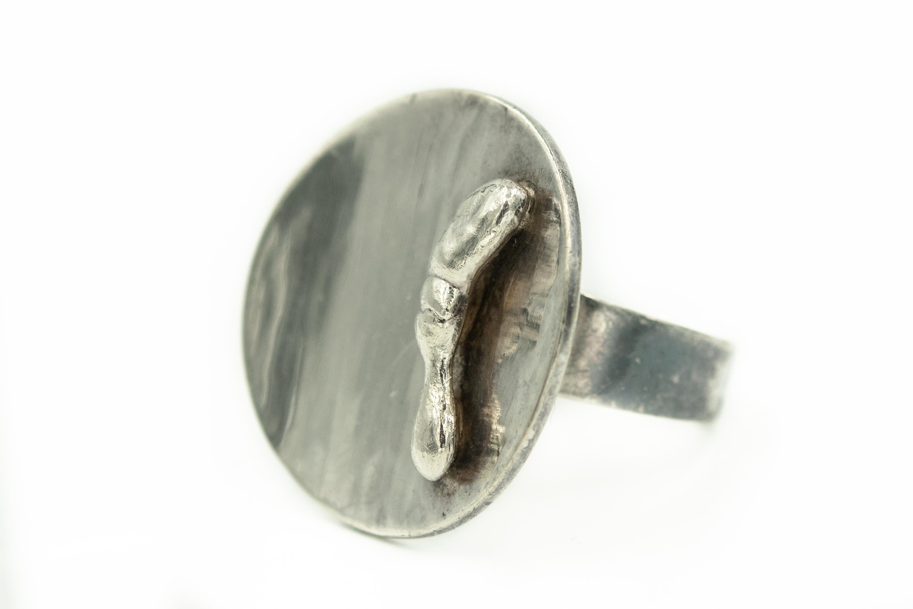 IB Bluitgen Denmark Sterling Silver 925 
Vintage Denmark Scandinavian hammered style concave modernist ring with applied hand holding flame.
US ring size 7.5
Marked Denmark IB 925

Ib Bluitgen trained as a silversmith at the Georg Jensen