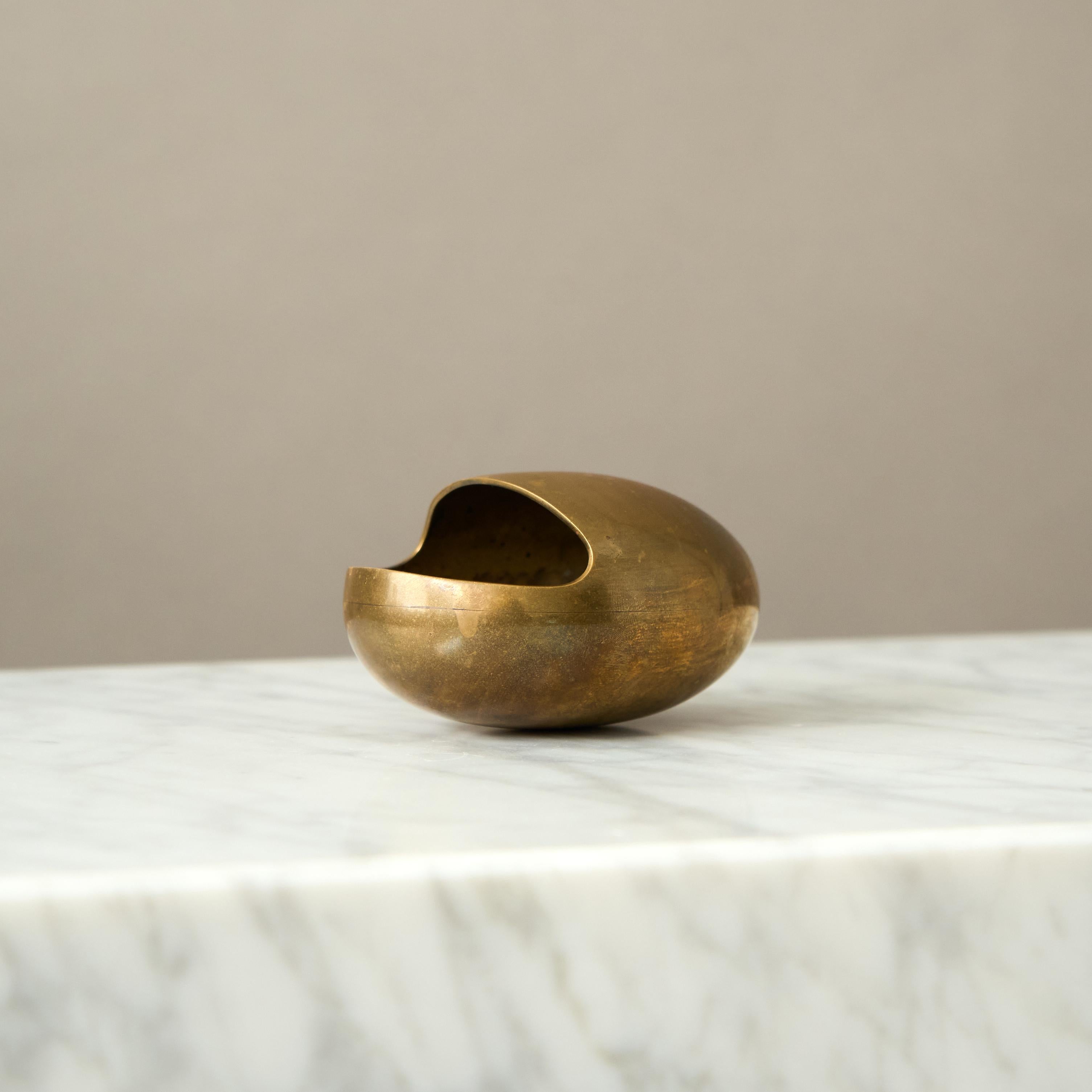 Iconic egg shaped Brass Ashtray. It is called 'the Smile' and was designed by silversmith Hans Bunde and manufactured by Carl Cohr in Fredericia, Denmark during the 1950s. 
Stamped Cohr, Denmark - to the base. 
It remains in beautiful un-polished