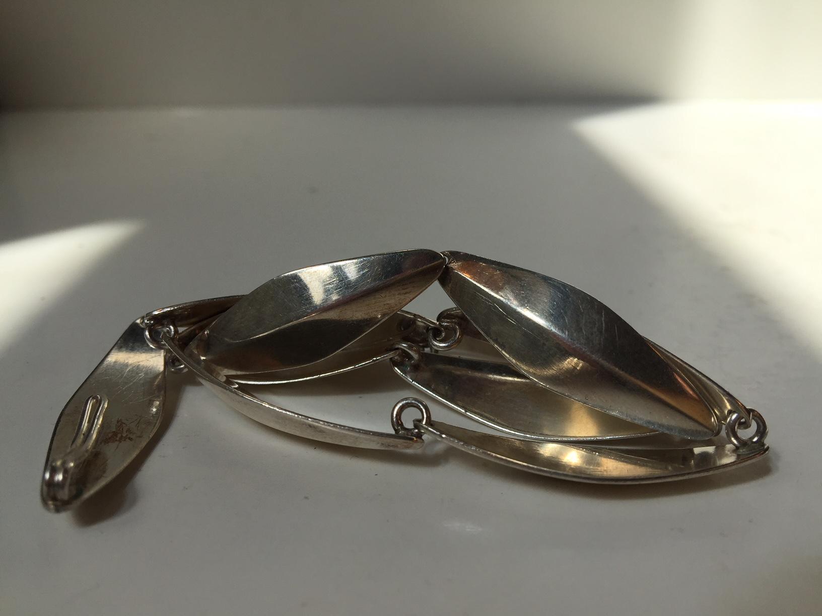 This Mid-Century Modern necklace sometimes referred to as peak or leaf was made by the Danish silversmith Bent Knudsen. Bent Knudsen designed for the Hans Hansen Silver Smithy before opening his own studio in 1956. The catch of the necklace is