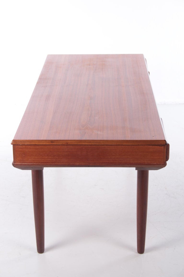 Danish modern table with pass-through drawers with bow tie by Dyrlund, 1960s, made in teak, fitted with a shelf with a drawer at each end.

The drawers are decorated with stylish handles, clearly inspired by Arne Vodder and his signature handle,