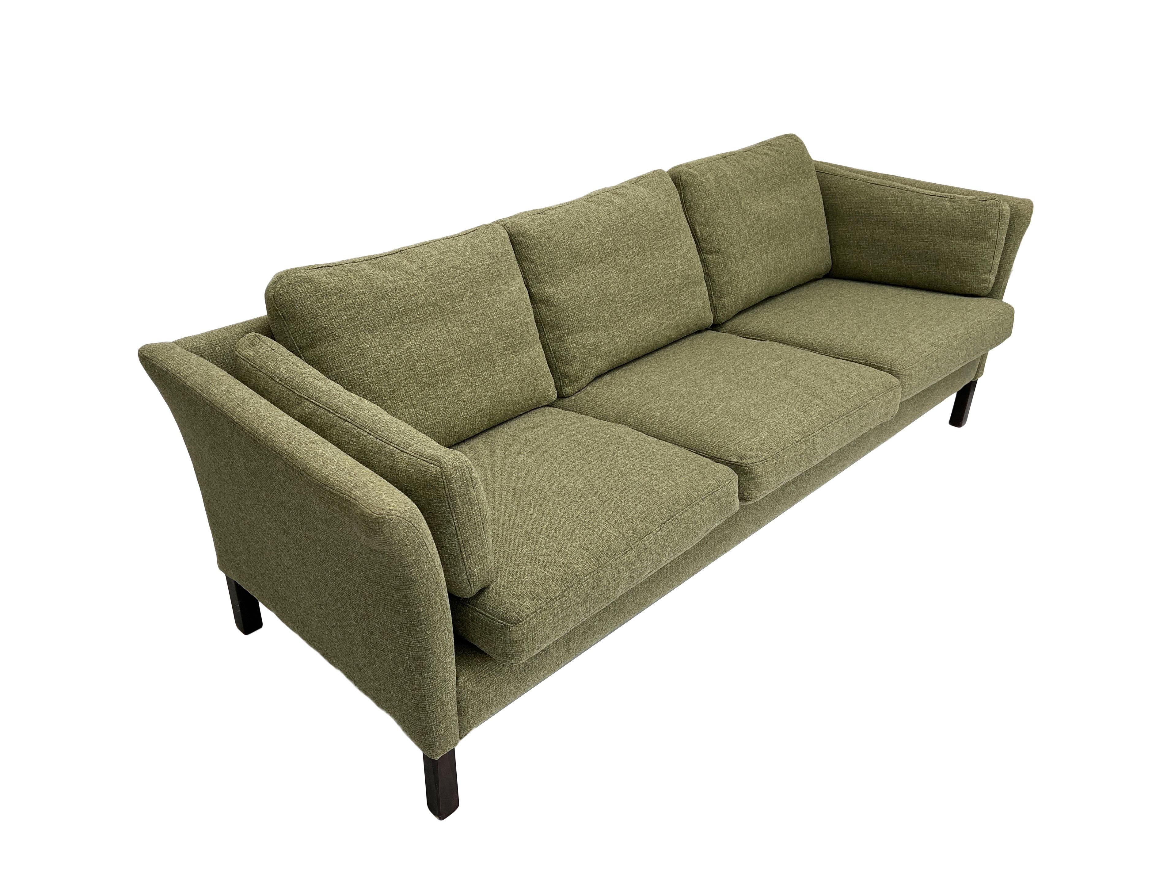 Ce magnifique canapé danois 3 places en laine vert sauge, créé par Sage Hansen, est un ajout élégant à tout espace de vie ou de travail.

Le canapé est doté de larges assises et d'accoudoirs paddés pour un meilleur confort. Un meuble scandinave