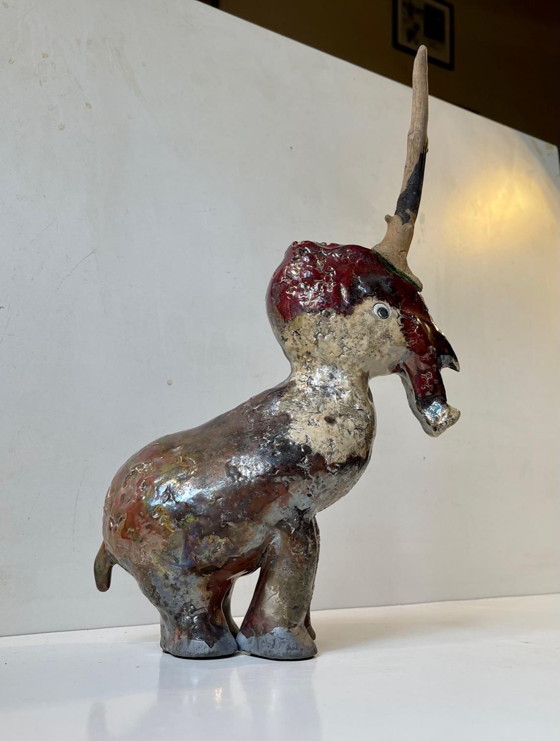 Unique artist/ceramist signed unicorn in Baku burnt stoneware. A waste variety of different glaze colors and the 'horn' itself is actually made from wood. Unknown/un-identified Danish ceramist circa 2000 is a style reminiscent of Sten Lykke Madsen.