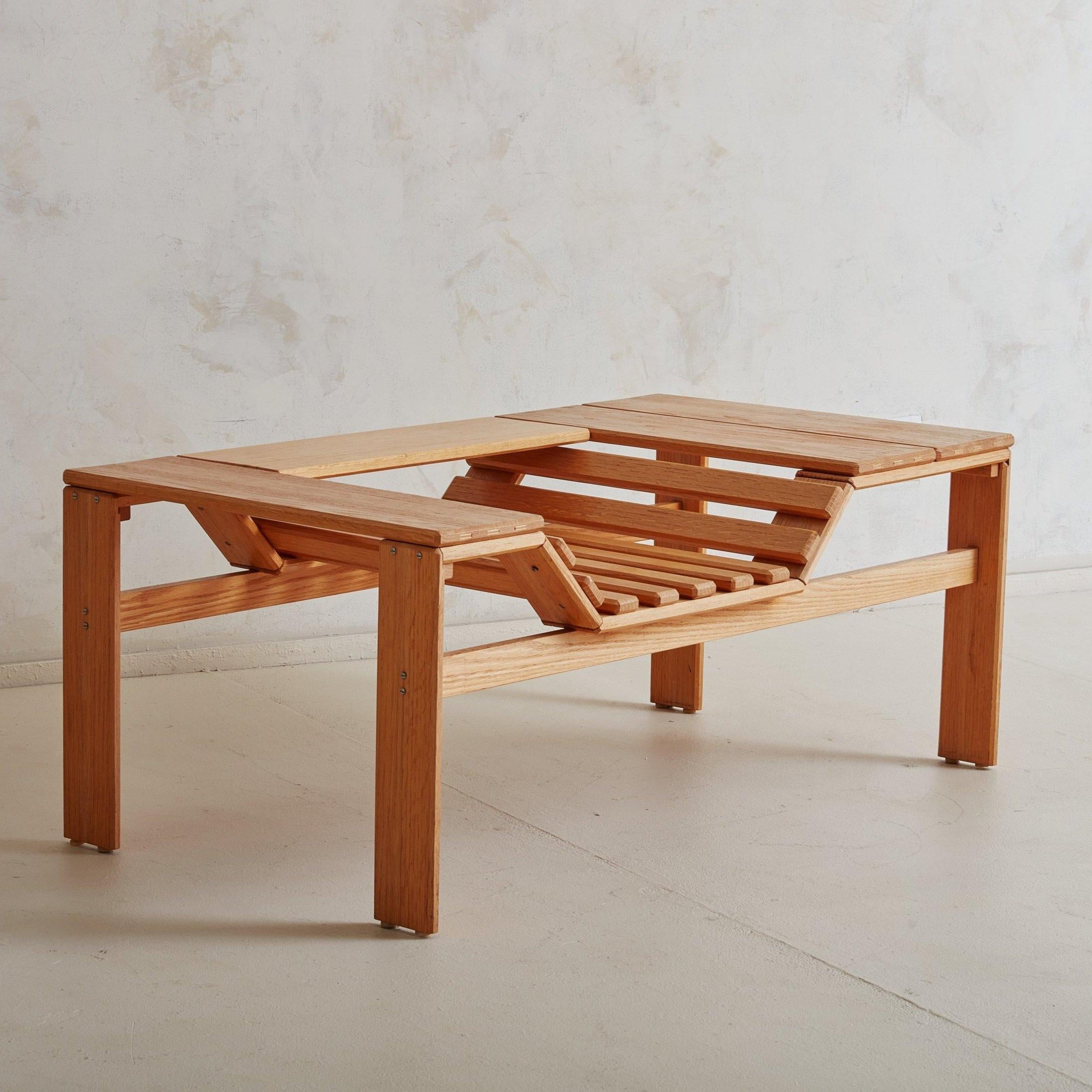 A Danish Modern wood bench or coffee table featuring clean lines and a natural blonde finish. This architectural form bench is exceptionally well made with four sturdy legs attached by exposed metal hardware. The slatted inset seat doubles as a