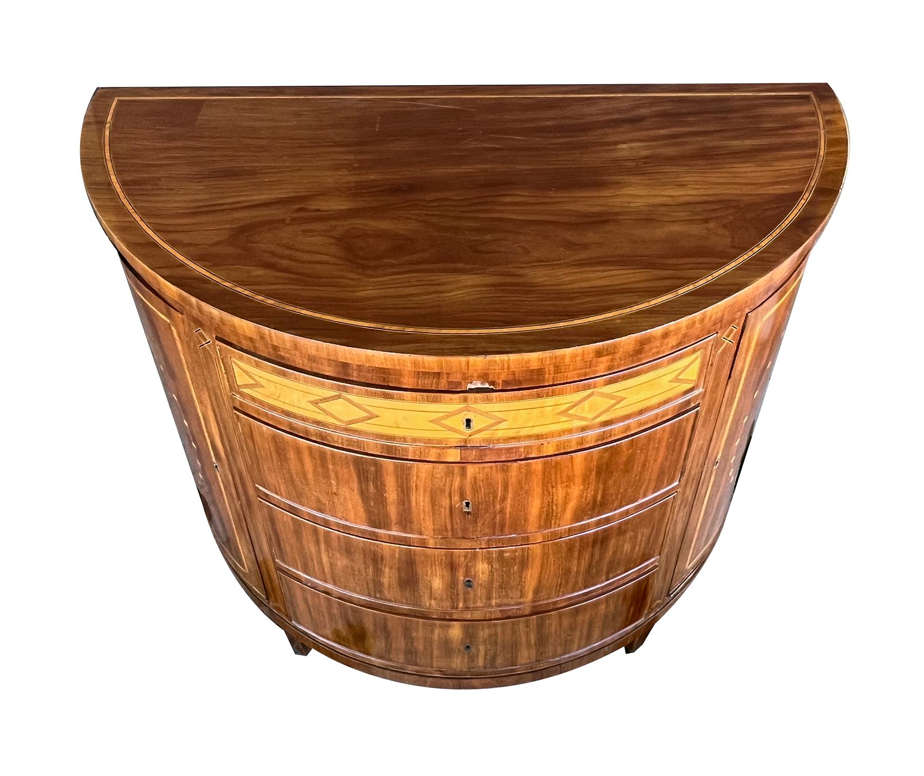 the half-round top over a conforming base inlaid with satinwood inlay and ebony stringing; fitted with four drawers flanked by two hinged doors; raised on short tapering legs; paper label 'Han Larsen, Kallundborg, Kjobenhavn'