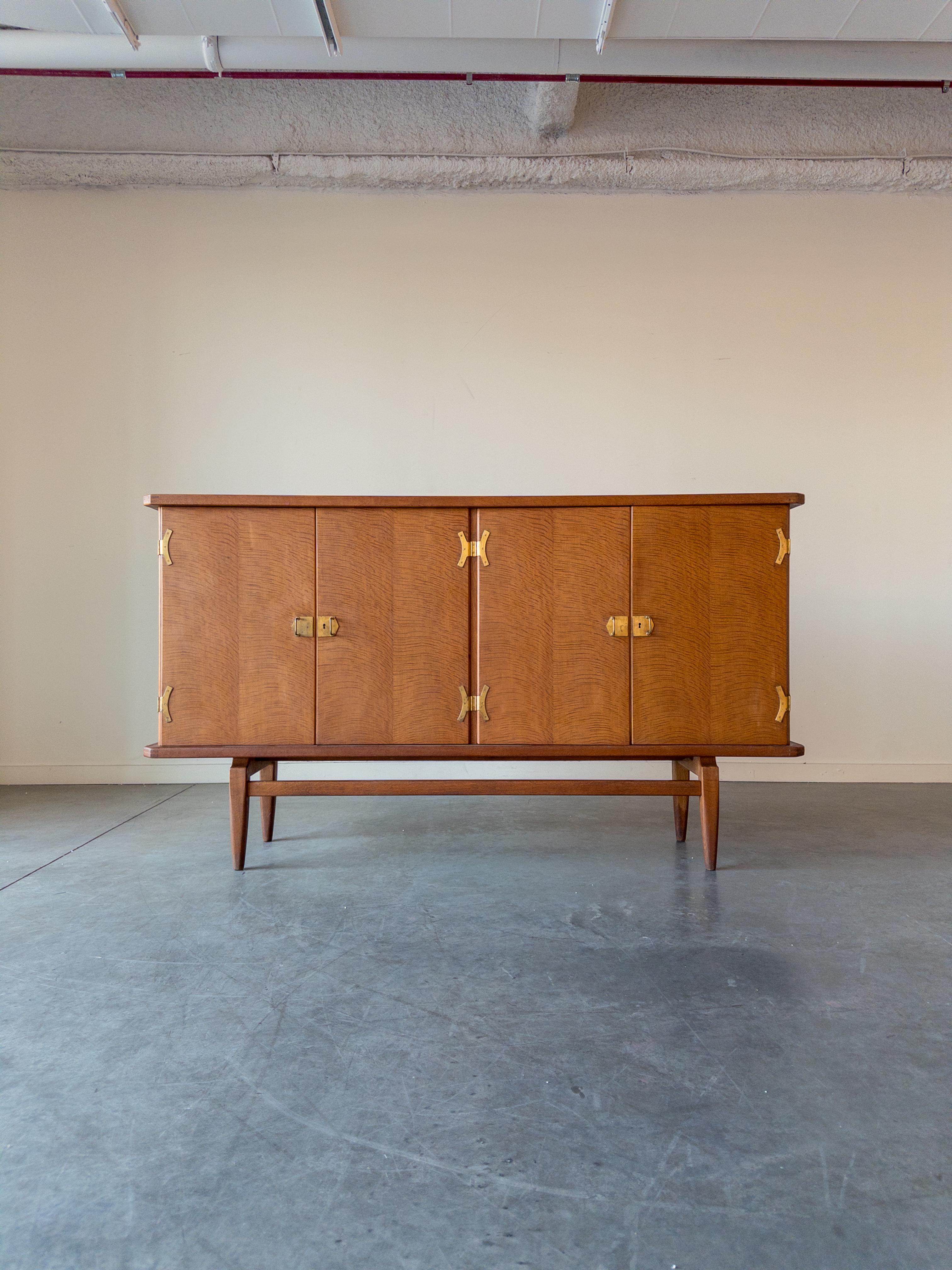 Rara credenza in Oak e ottone di Henning Kjærnulf, Danimarca, anni Settanta. Creato dal visionario designer danese Henning Kjærnulf. La credenza è realizzata in rovere danese, noto per la sua resistenza e per le sue venature distinte. L'aggiunta di
