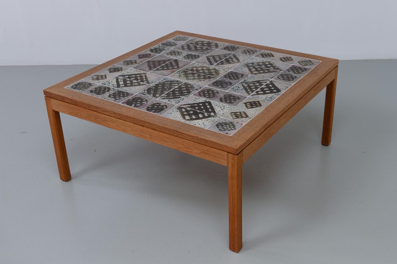 Danish Oak and Tile Coffee Table by Tue Poulsen, 1960s. 

Scandinavian Mid-Century Modern coffee or cocktail table in solid Nordic with handmade ceramic tiles made by artist Tue Poulsen, Denmark.
This unique square coffee table with earth colored
