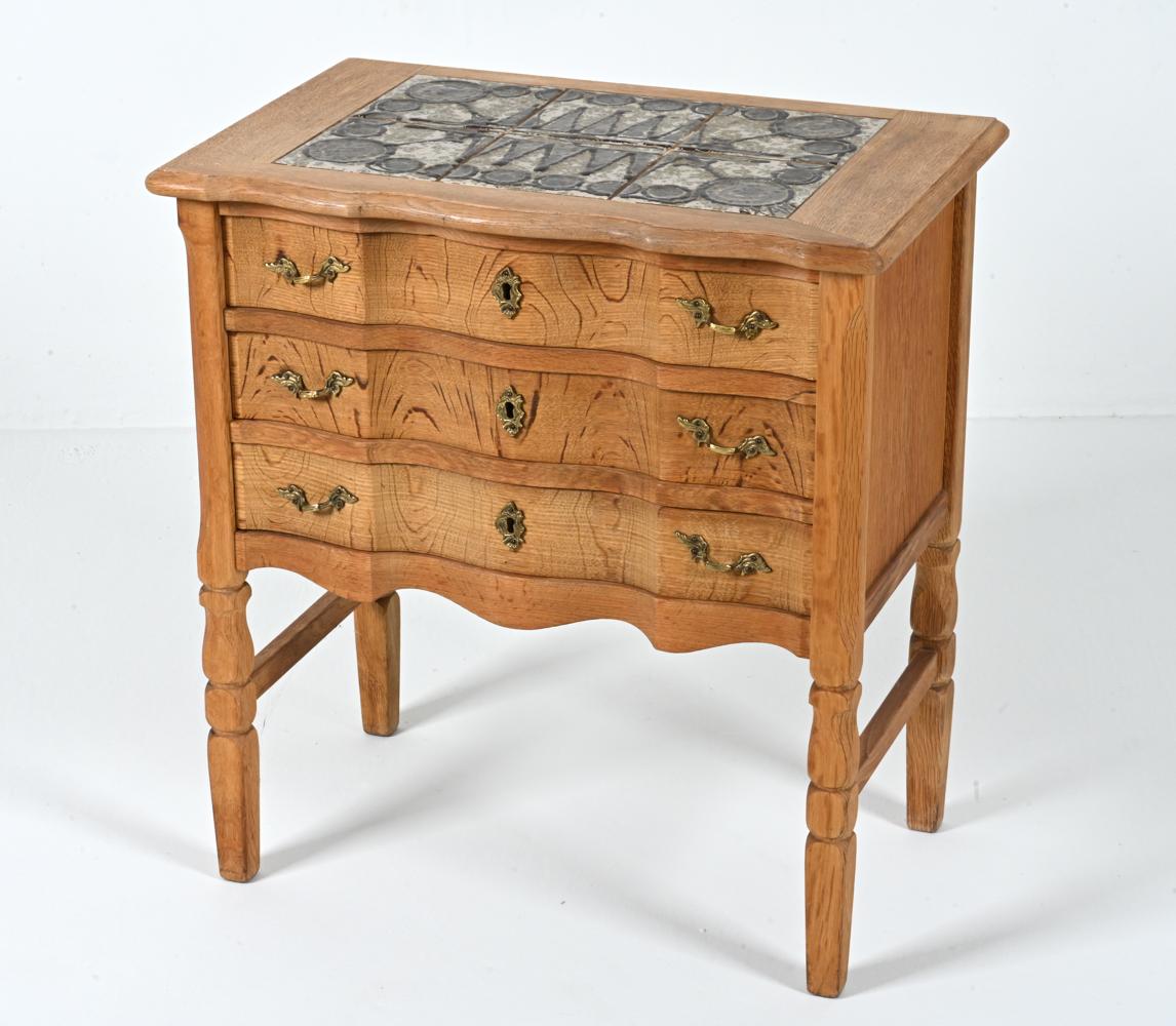 Capture the free spirit of the 1970's with this one-of-a-kind side chest, which features an abstract mosaic of six hand-crafted studio ceramic tiles by Ox Art, inset atop a body of stunning quarter-sawn white oak. 

Inspired by the work of Henning