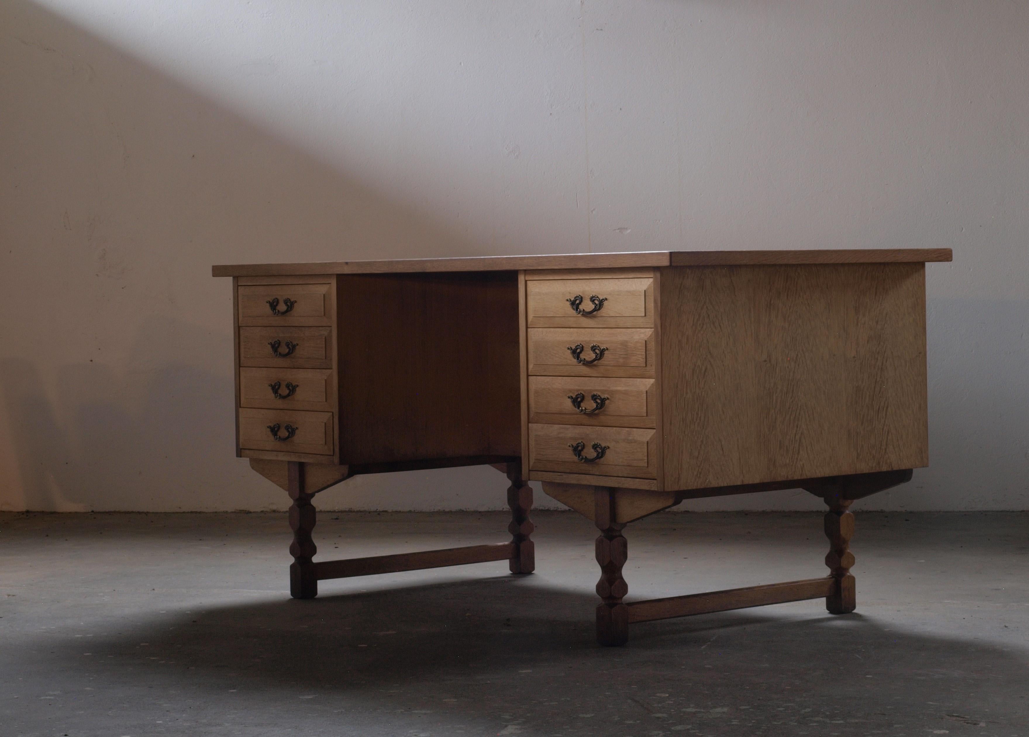 Bureau en chêne massif avec tiroirs, attribué au designer de meubles danois Henning Henry Kjærnulf, une pièce fascinante. Cette création mêle harmonieusement des éléments baroques audacieux à la finesse du modernisme du milieu du siècle, ce qui