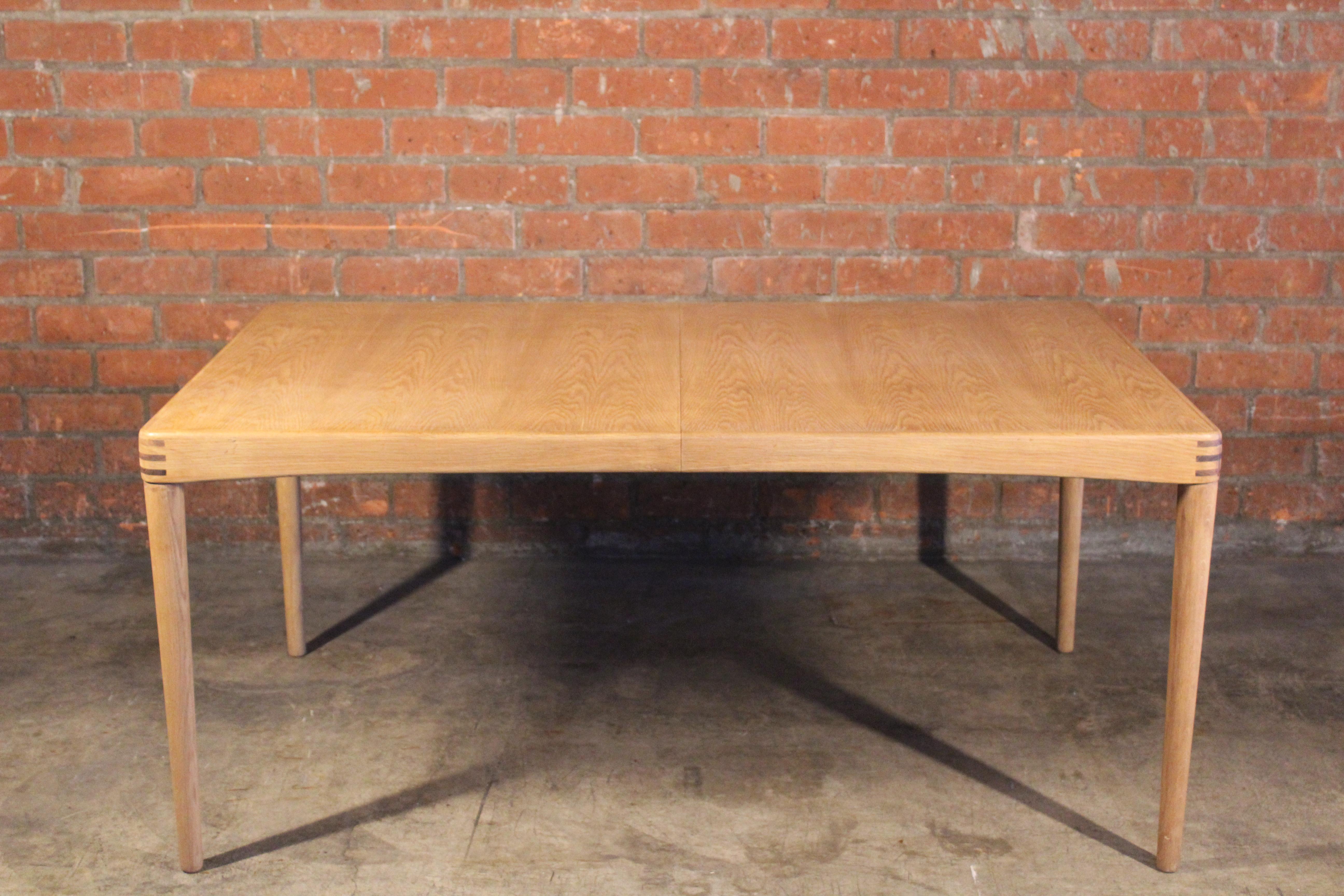 A vintage, extending dining table in oak designed by H.W Klein for Bramin Mobler, Denmark, 1960s. Beautuful rosewood details on the corners of the table. The table inlcludes one leaf. Extended it is 86.5 wide, not extended it is 63