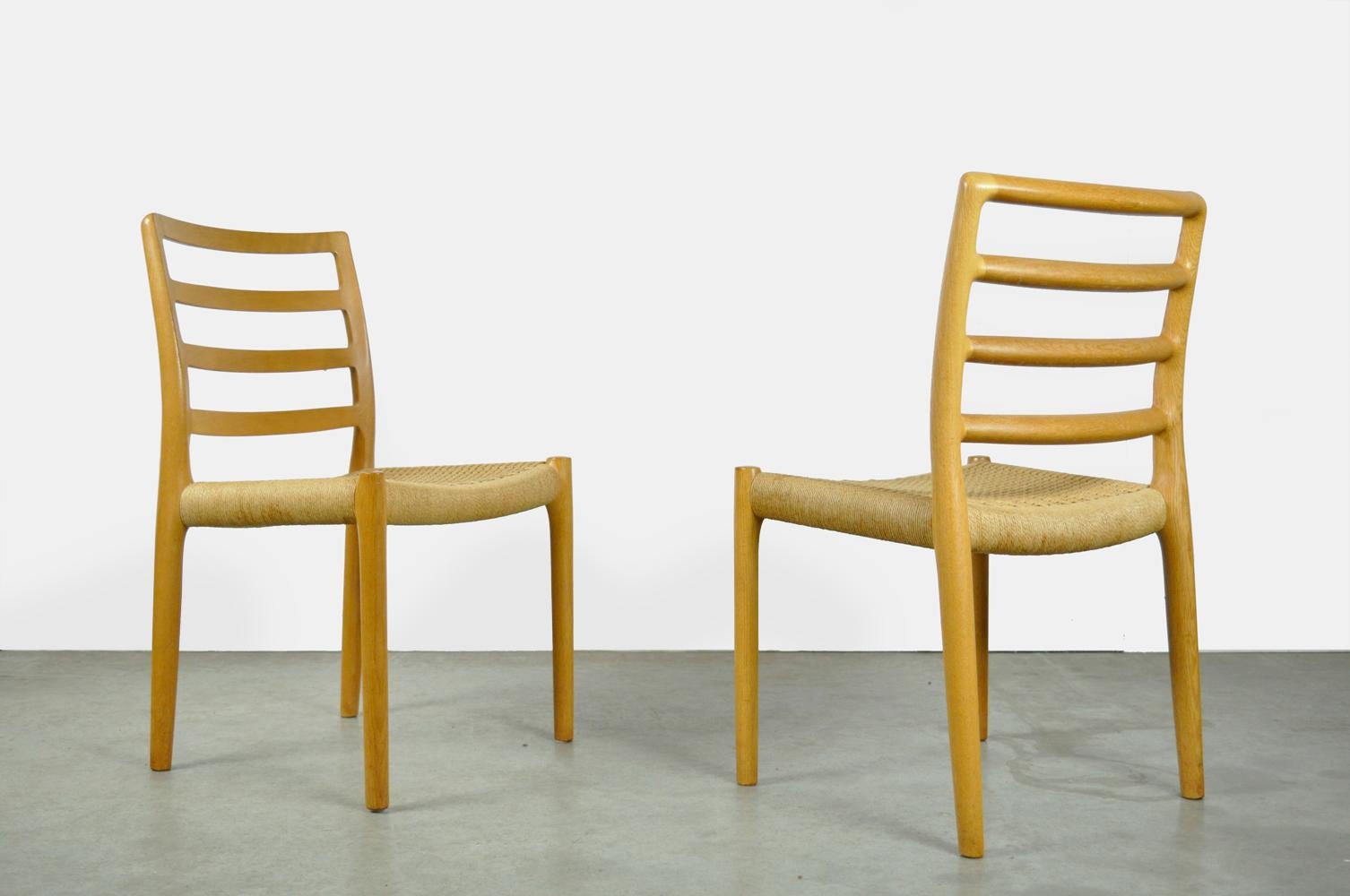 set of oak dining table chairs, model 85, designed by Niels Otto Moller and produced in Denmark by J.L. Mollers Mobelfabrik, 1970s. The frame of the elegant chairs is made of solid oak. The seat is stretched with rope (paper cord). The chairs are