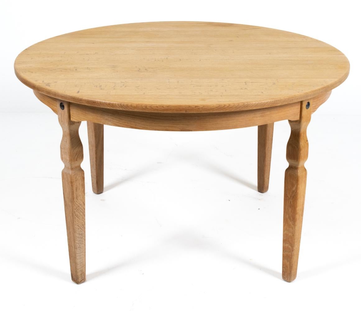 This beautiful circular dining table features solid quarter-sawn white oak construction, with soft sculpted legs and two inset leaves. An extra leg is provided to support the table when the leaves are in use. This piece would be stunning in a Modern