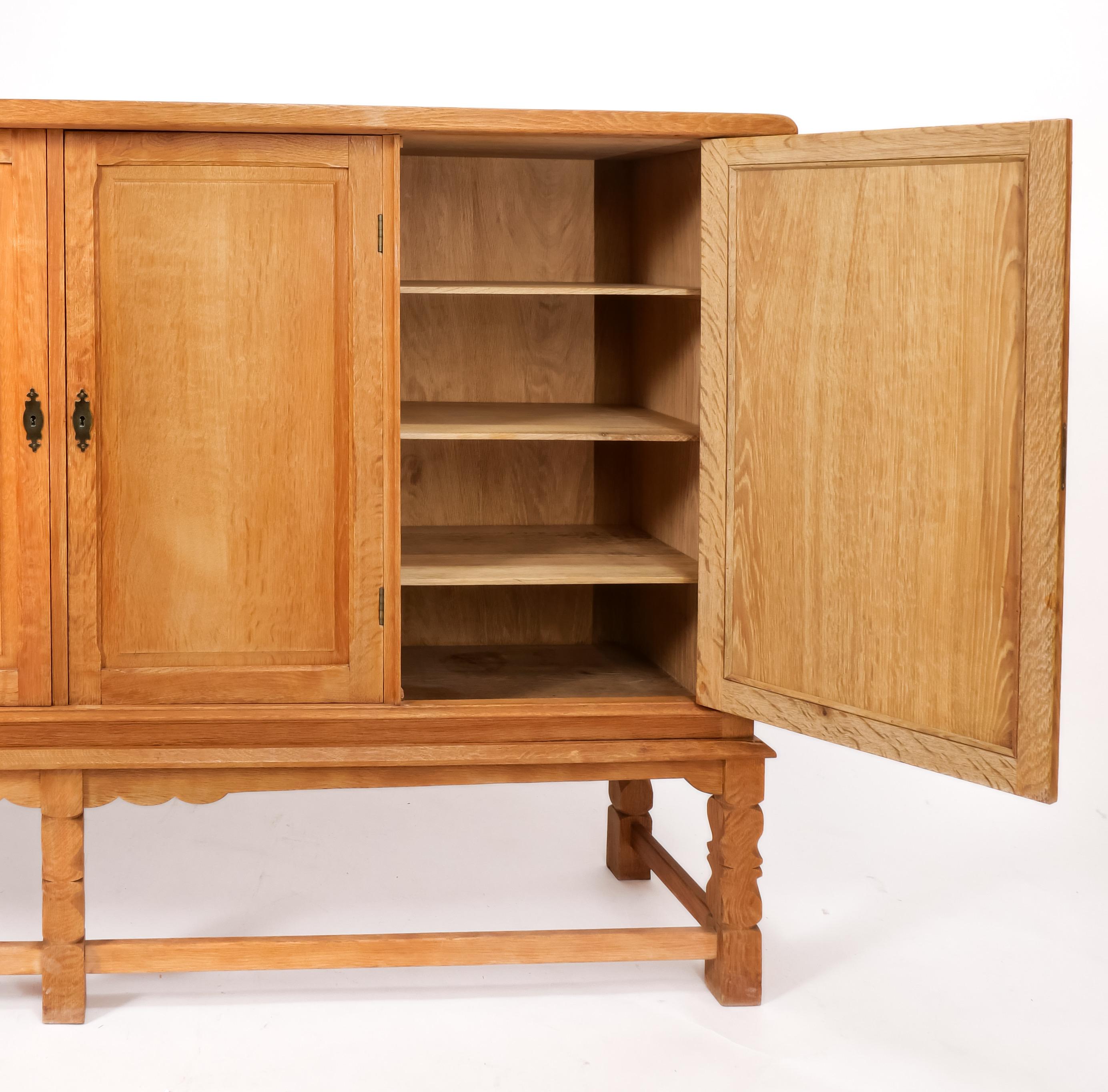Grand solid oak cabinet by Danish designer Henry Kjaernulf, sometimes known as “Henning.” His style is distinctive and characteristic of it are the whimsical almost baroque-styled legs. The pieces are both modern and rustic and work well in a