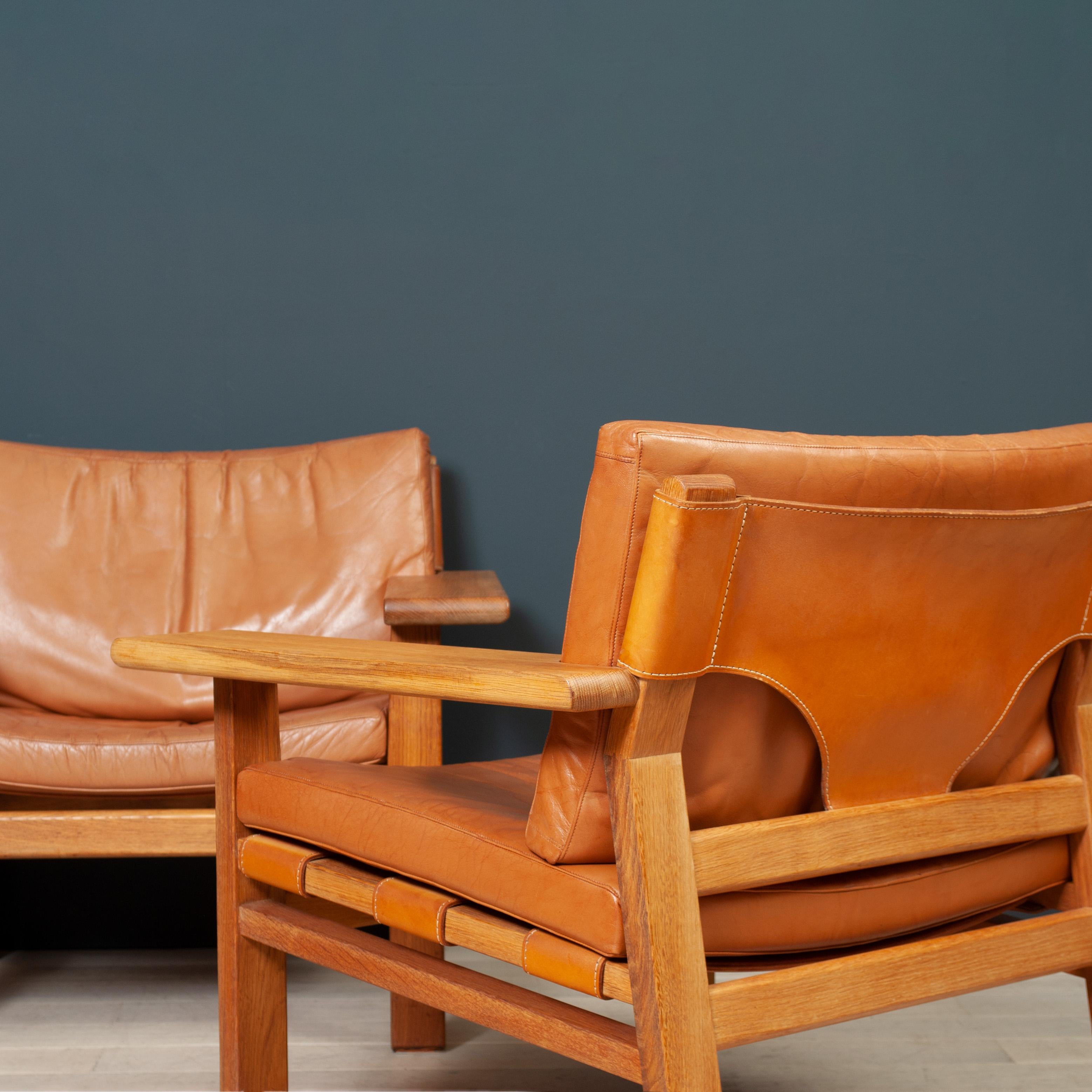 Hunter Spanish Lounge chairs by K.S Mobler circa 1960 - of the same period and in the manner of Borge Mogensen Spanish chairs - a nice alternative. Wonderful oversized oak arms with tan saddle leather sling and leather upholstered cushions. An