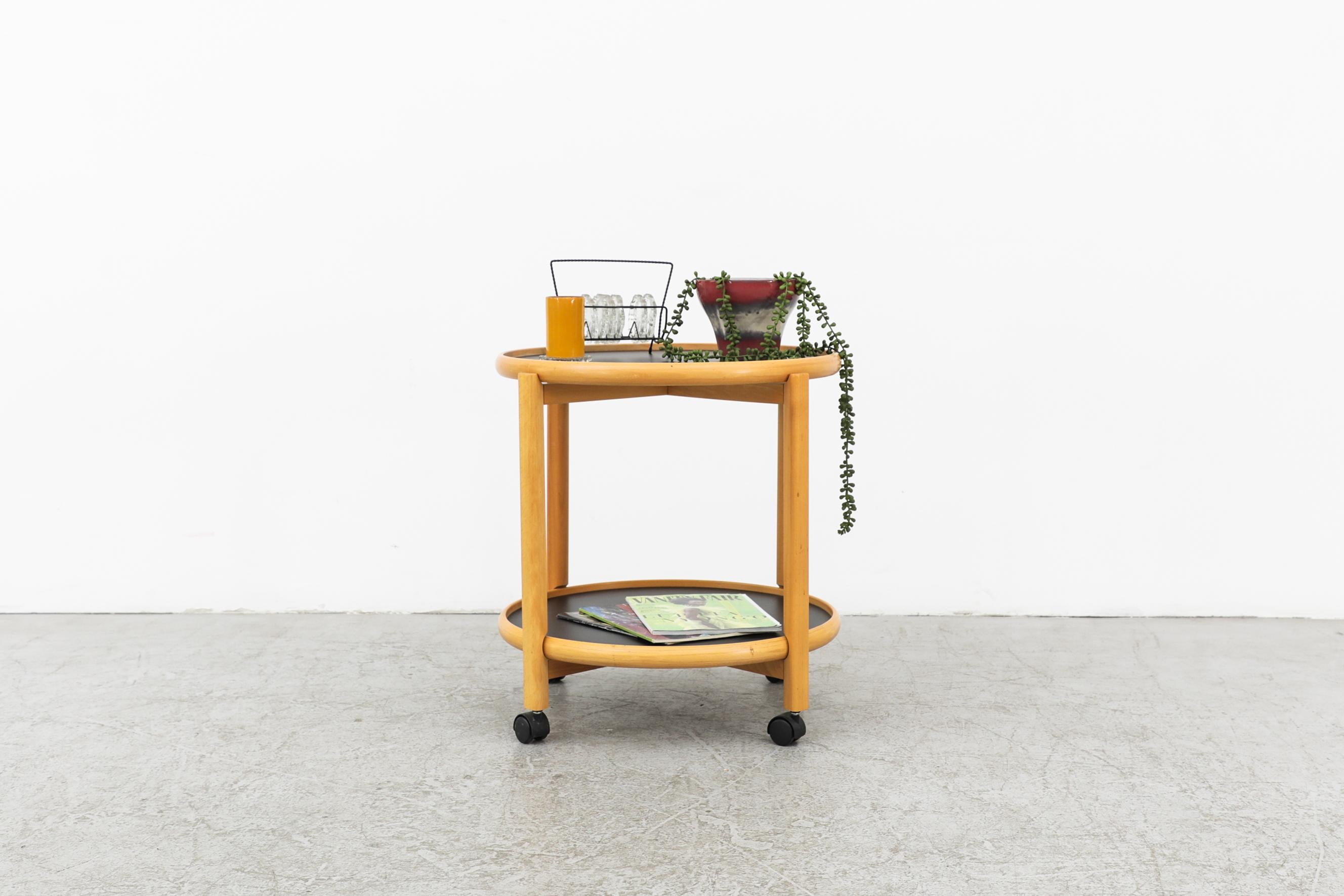 Danish oak rolling trolley with reversible tray top by Hans Bølling for Torben Ørskov, 1960s. The top flips from black laminate to white laminate. In original condition with visible wear including a white paint stain on the bottom shelf and some