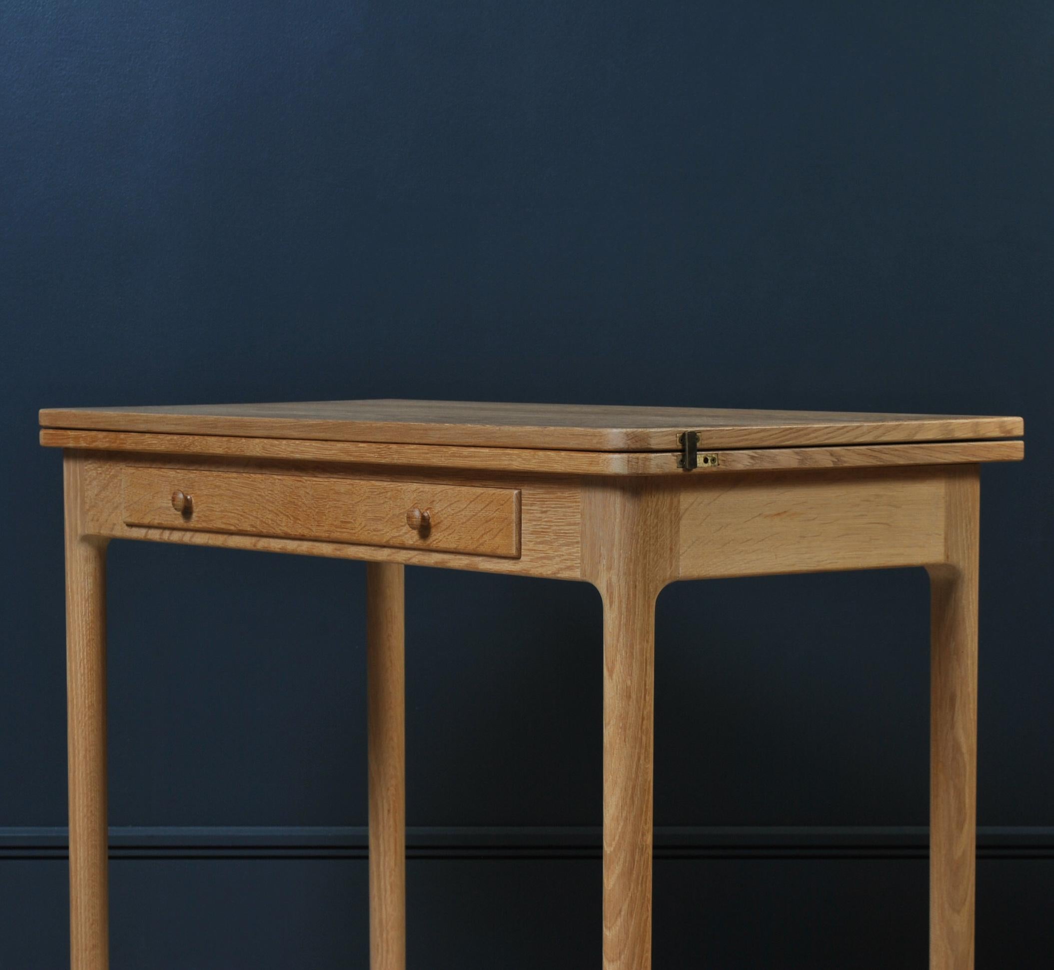 This wonderful little Midcentury European oak desk or console is incredibly well hand-crafted - not mass produced. The top can be unfastened, slid to one side and flipped open to create a larger table. Perhaps to serve as a games table etc. Either