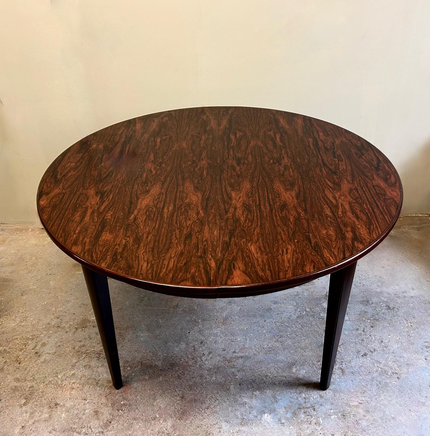 A beautiful Danish Model 55 rosewood dining table designed by Gunni Omann for Omann Jun Møbelfabrik, this would make a stylish addition to any dining or work area. A striking piece of classically designed Scandinavian furniture.

The table has a