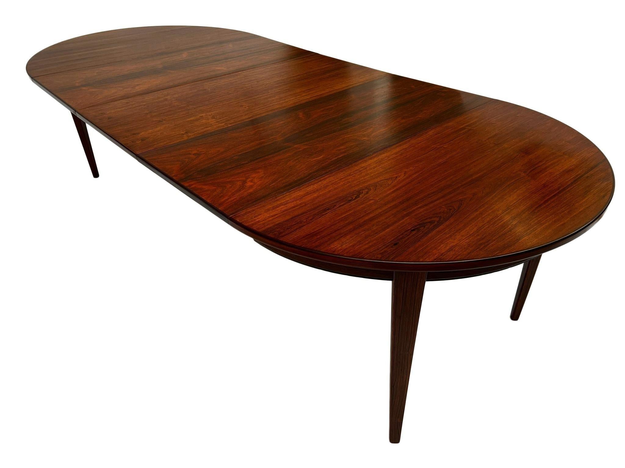 A beautiful Danish Model 55 rosewood dining table designed by Gunni Omann for Omann Jun Møbelfabrik, this would make a stylish addition to any dining or work area. A striking piece of classically designed Scandinavian furniture.

The table has