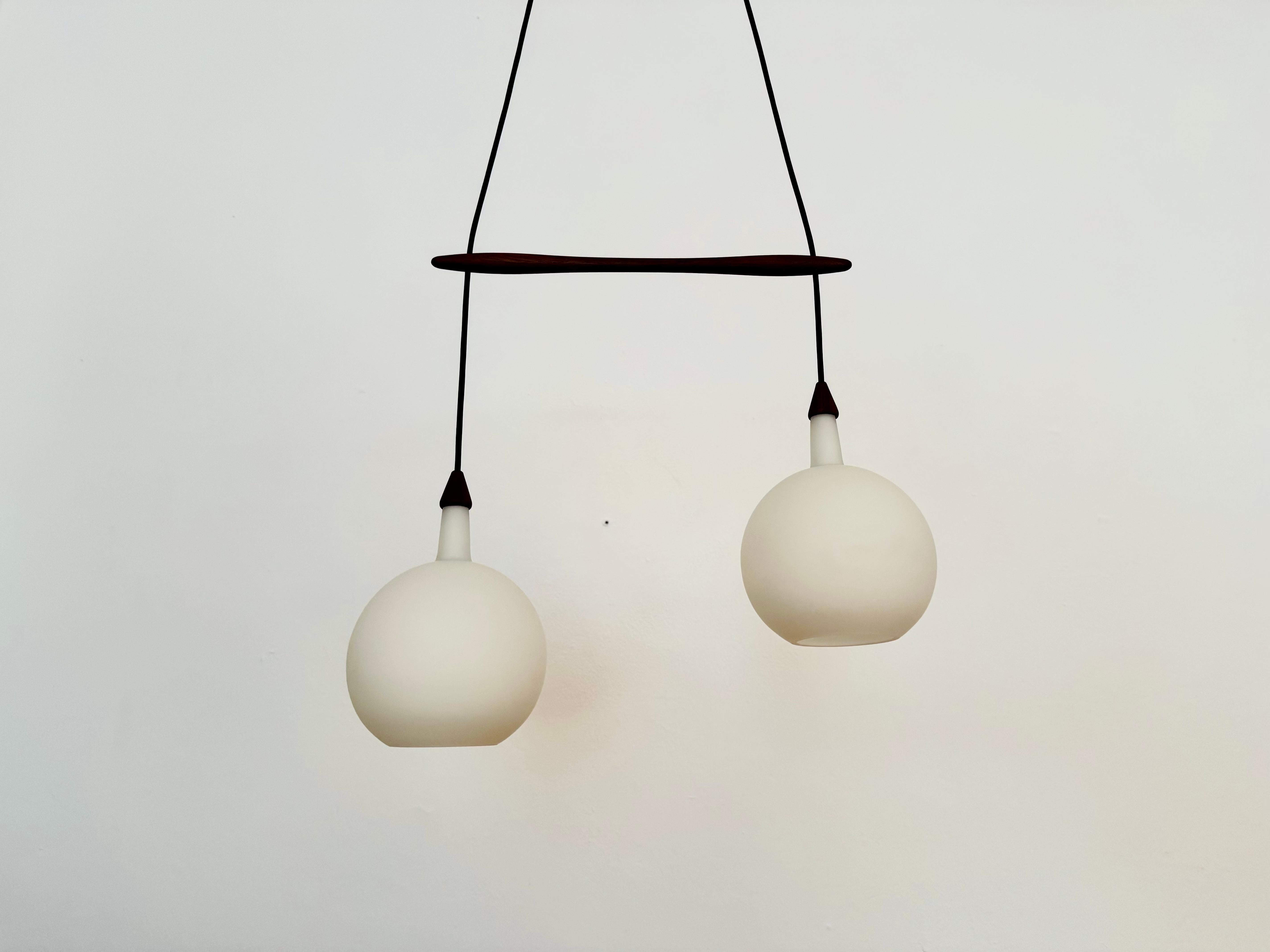Splendida lampada danese a cascata in vetro opalino degli anni '60.
Un design eccezionale e minimalista con un fantastico aspetto nobile.
Dettagli in teak molto belli.

Produttore: Nordisk Solar

Condizioni:

Condizioni vintage molto buone con lievi