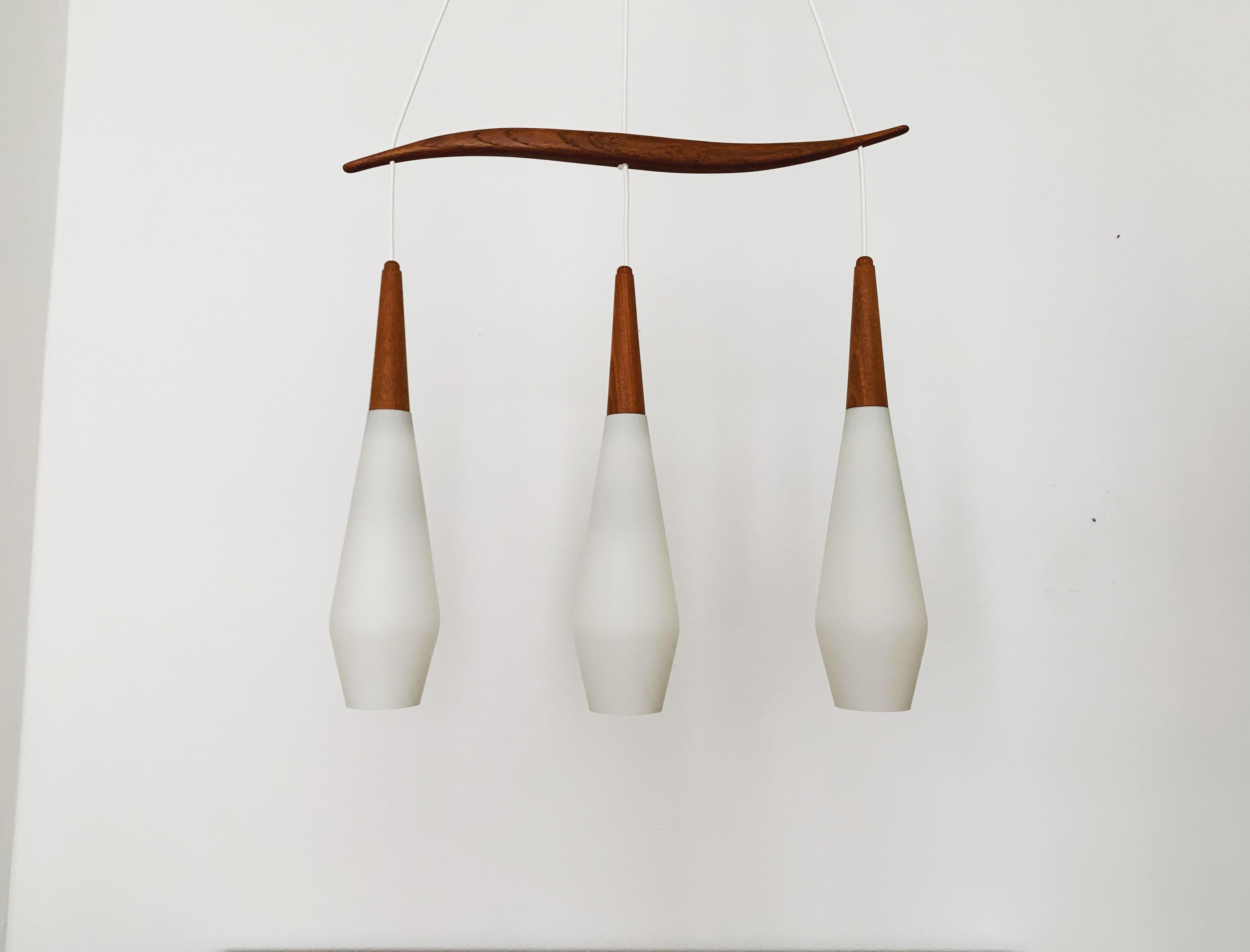 Splendida lampada a sospensione in vetro opalino degli anni '60.
Un design fantastico ed eccezionalmente minimalista con un look incredibilmente elegante.
Dettagli in teak molto belli.

Condizioni:

Condizioni vintage molto buone con lievi
