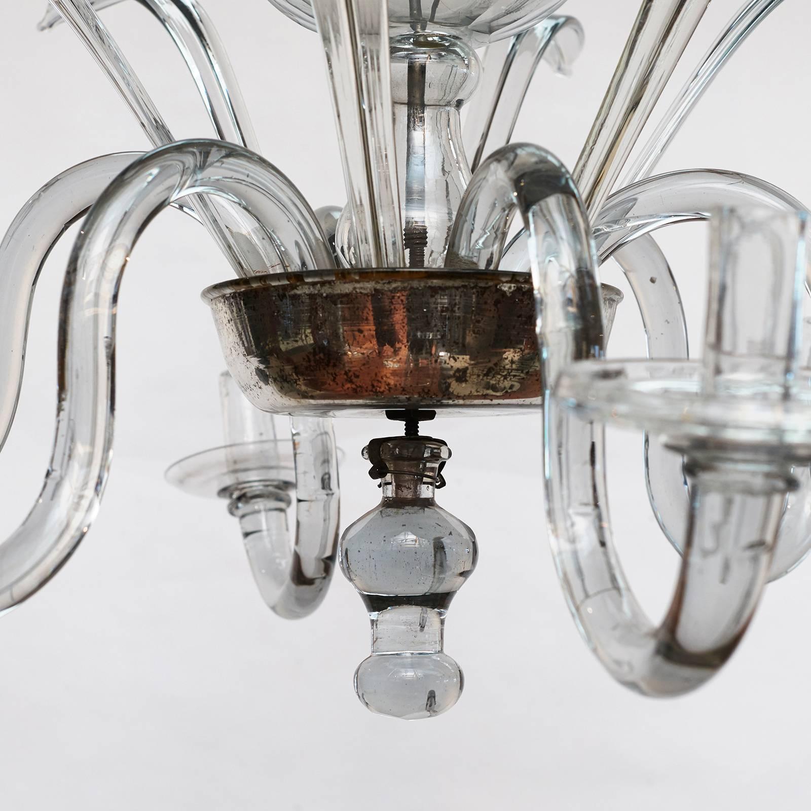 An elegant Danish or possibly North German Baroque crystal glass chandelier, circa 1750s, the corona issuing ten leaves, the central stem with baluster and sphere shapes, the lower silvered bowl issuing six scrolled arms. 
Not wired.