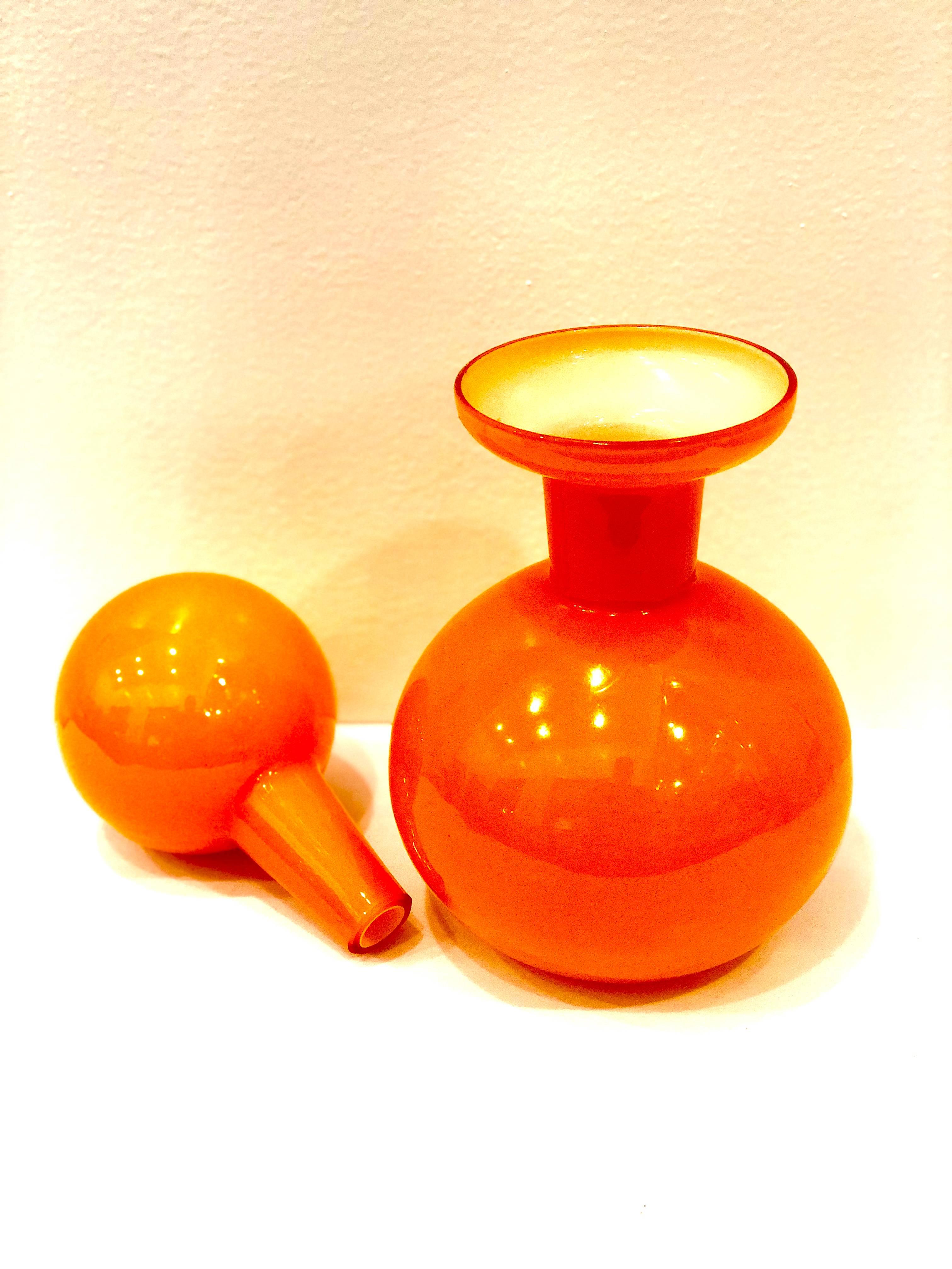 Iconic Danish modern handblown Art Glass bottle are in the most delicious shade of orange that will be a gorgeous pop of color in your decor. Designed by Otto Brauer for Holmegaard in excellent condition with no chips, cracks or scratches.