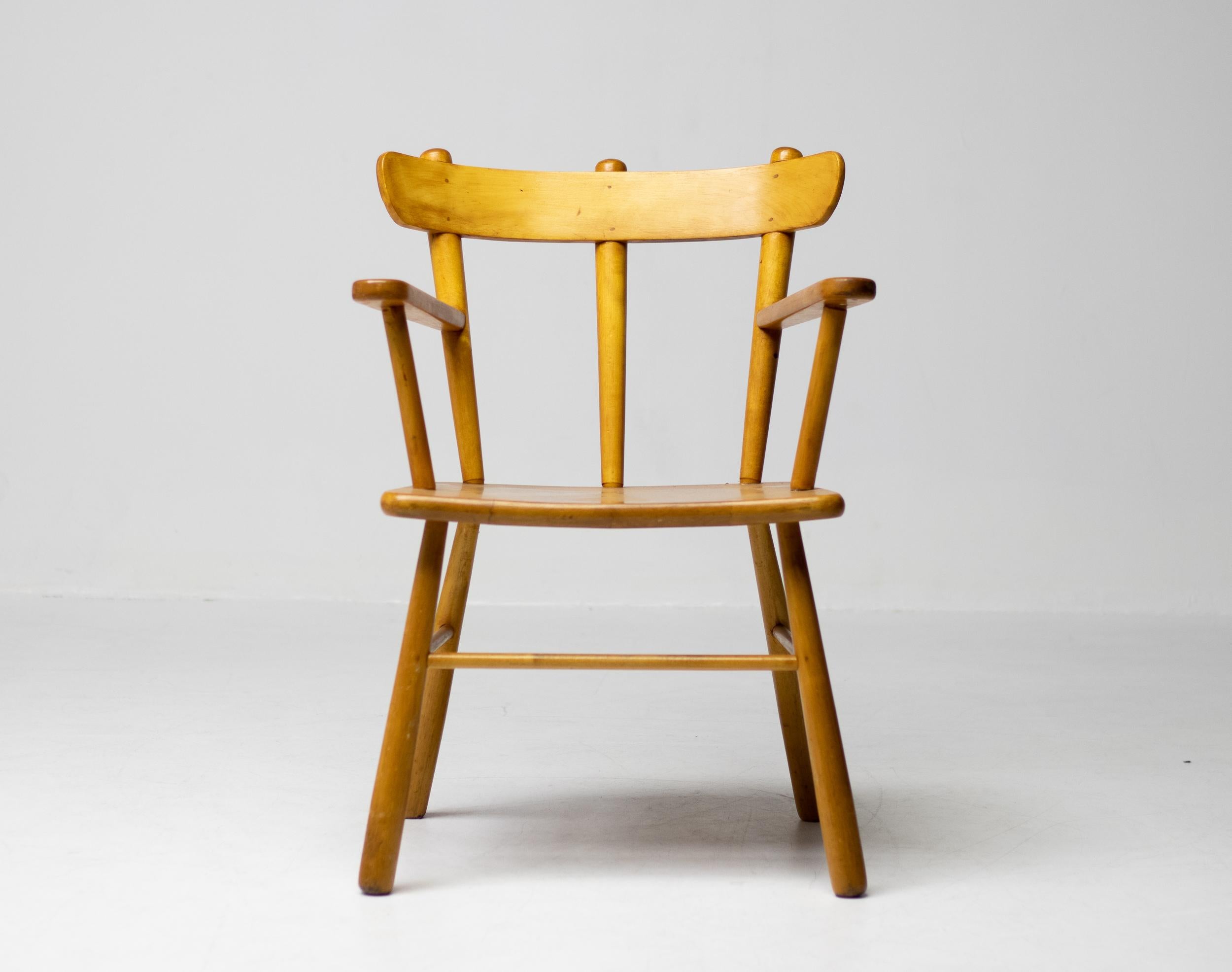 Beautiful organic arm chair in solid honey colored birch. A simplistic design with a round seating and attention for the natural expression and grain of the wood. This chair holds a beautiful curved back and solid tapered legs. The grain of the pine