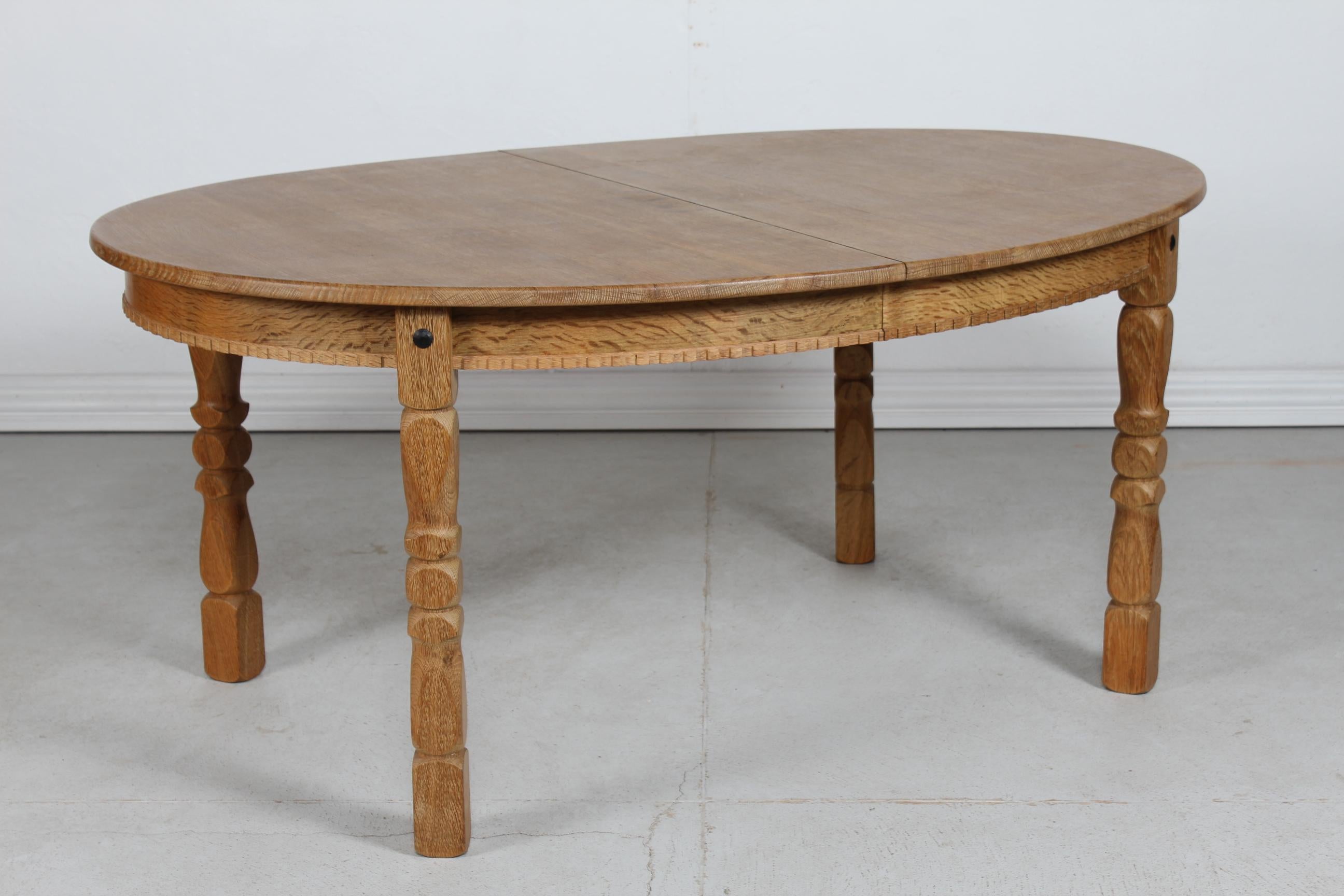 Danish vintage Henning Kjærnulf style oval extendable dining table with turned and carved legs.
Manufactured in Denmark in the 1970s. most likely by EG Møbler

The table is made of solid and oak veneer.
It can be extended with two leaves.