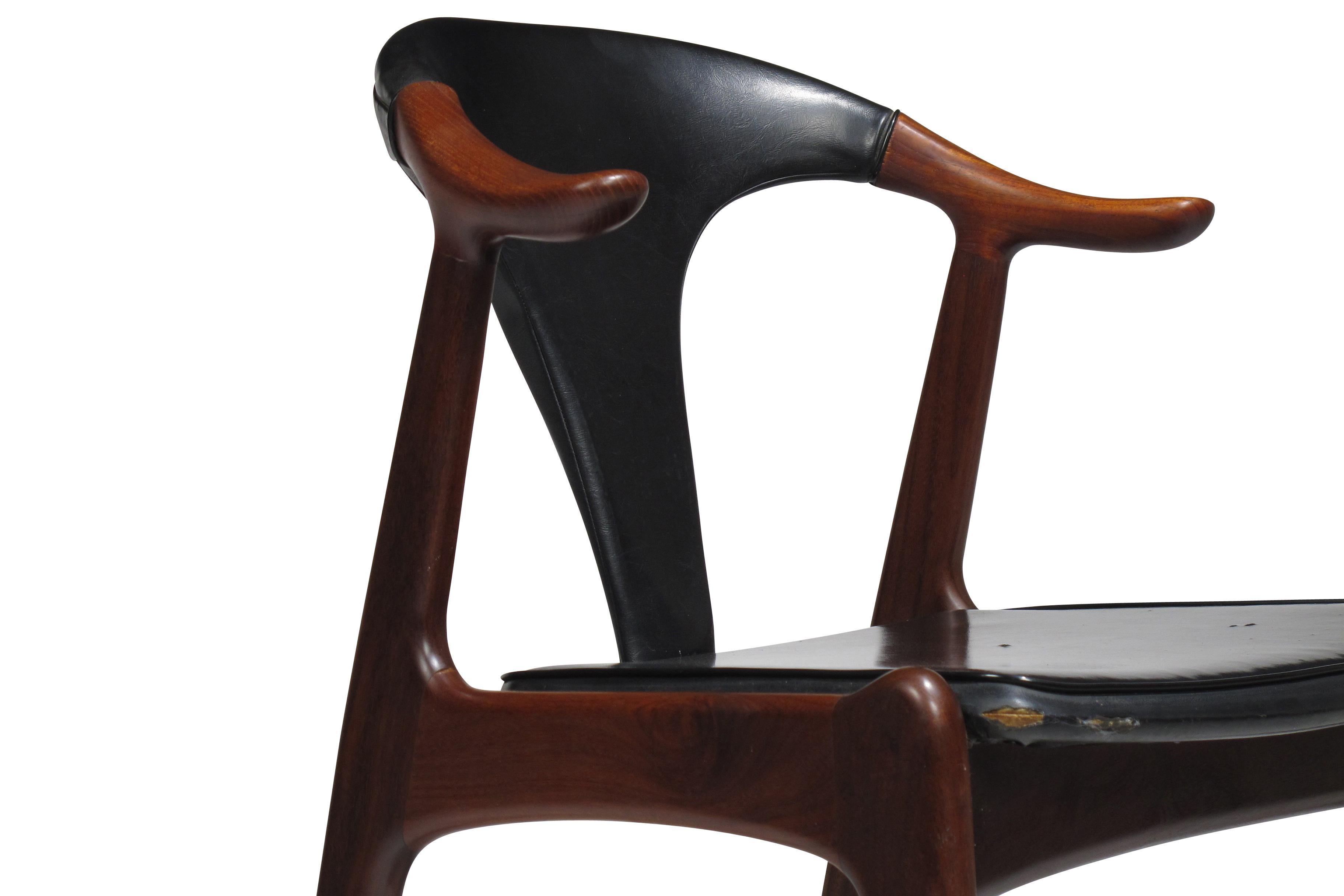 Ox armchair in the manner of Kurt Ostervig. The chair features a solid teak frame, sculpted teak arms, and original black vinyl upholstery. Custom upholstery options are available upon request.