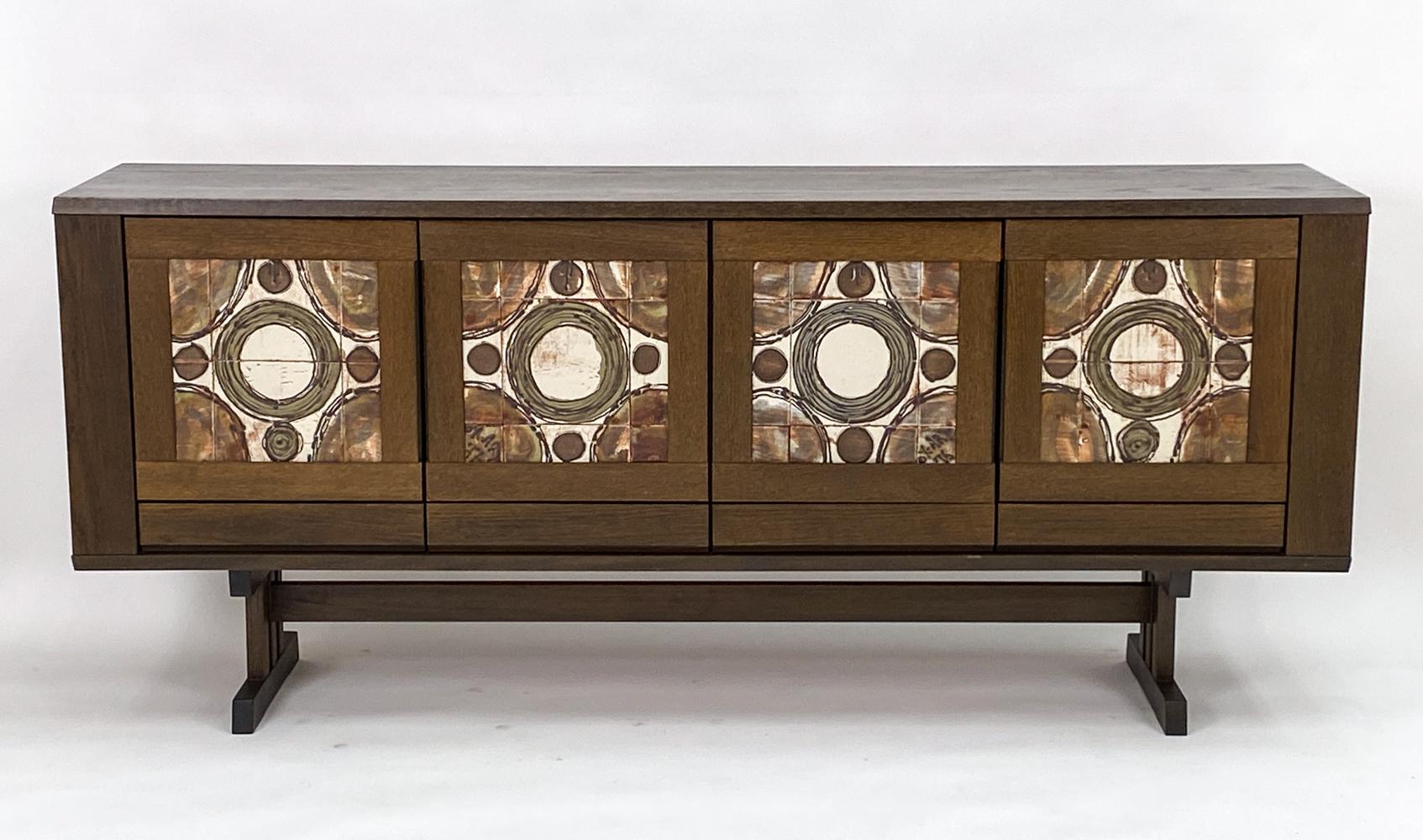 This is a fabulous trestle base sideboard in rich, dark stained oakwood made by Skovby, circa 1970s. This piece features ceramic abstract neutral earth-toned design 