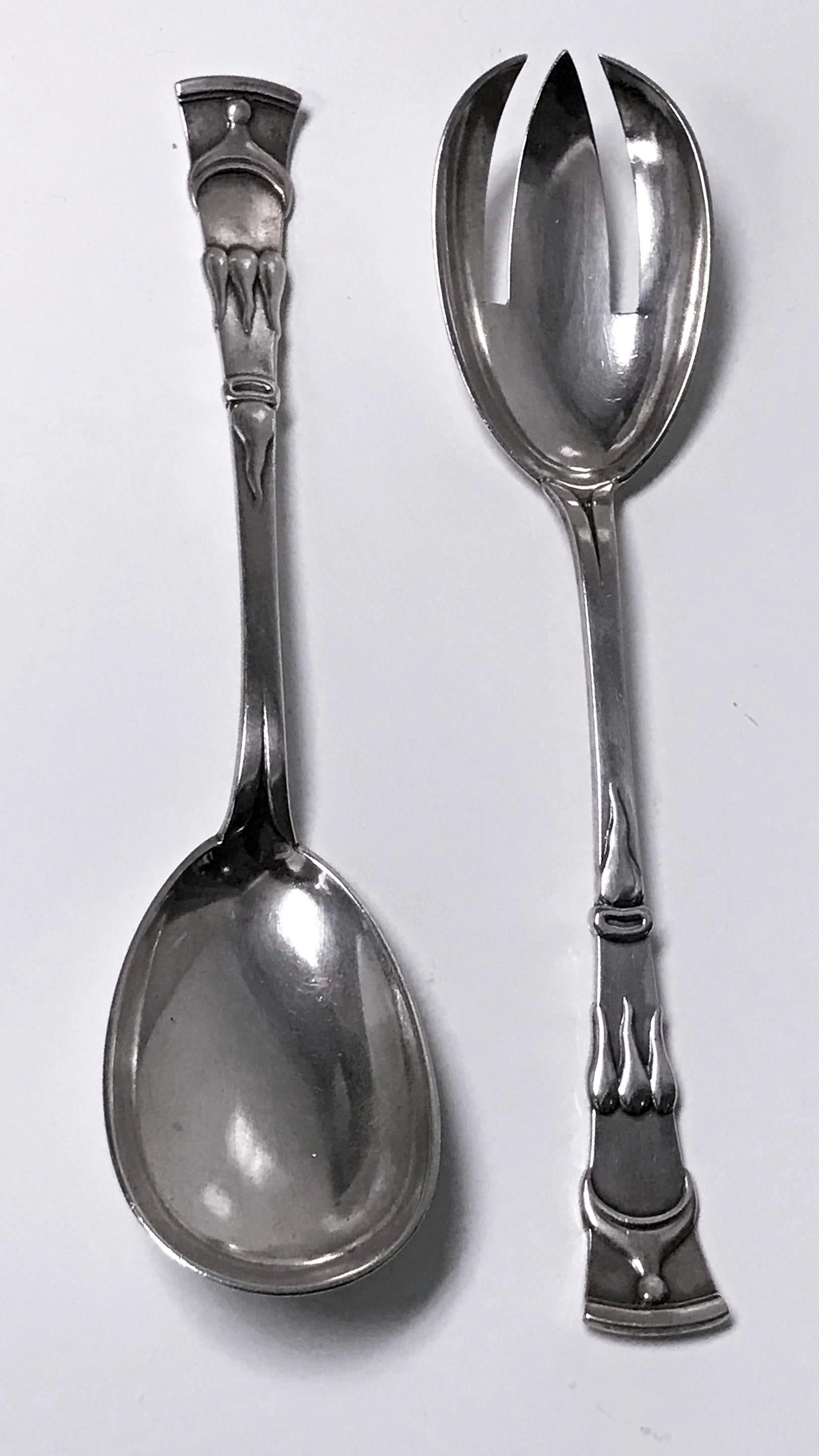 Pair of Danish Art Nouveau silver salad servers Copenhagen, 1909, P. Hertz Each with an egg-form bowl and spreading strap handle cast in relief with organic designs. Measures: Length 8.25 ins, Weight 4.5 oz.