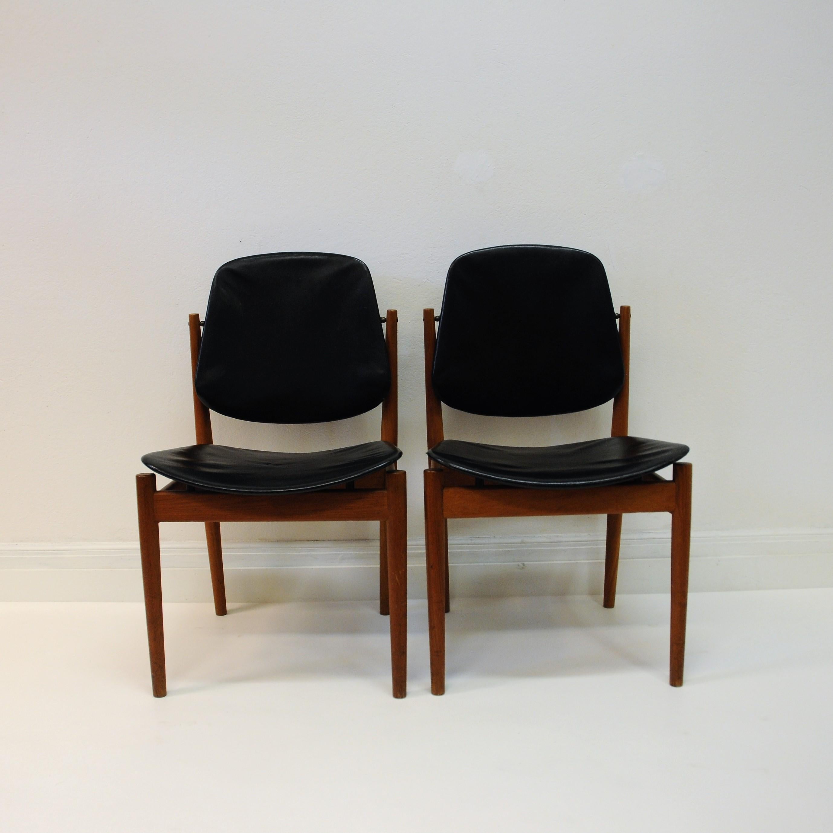 A nice pair of Arne Vodder dining chairs of solid teak and seats and backrests in the original black leather. These chairs has a tilting back part to adjust to a more comfortable seating. Designed 1956 and manufactured by France & Søn, Denmark.