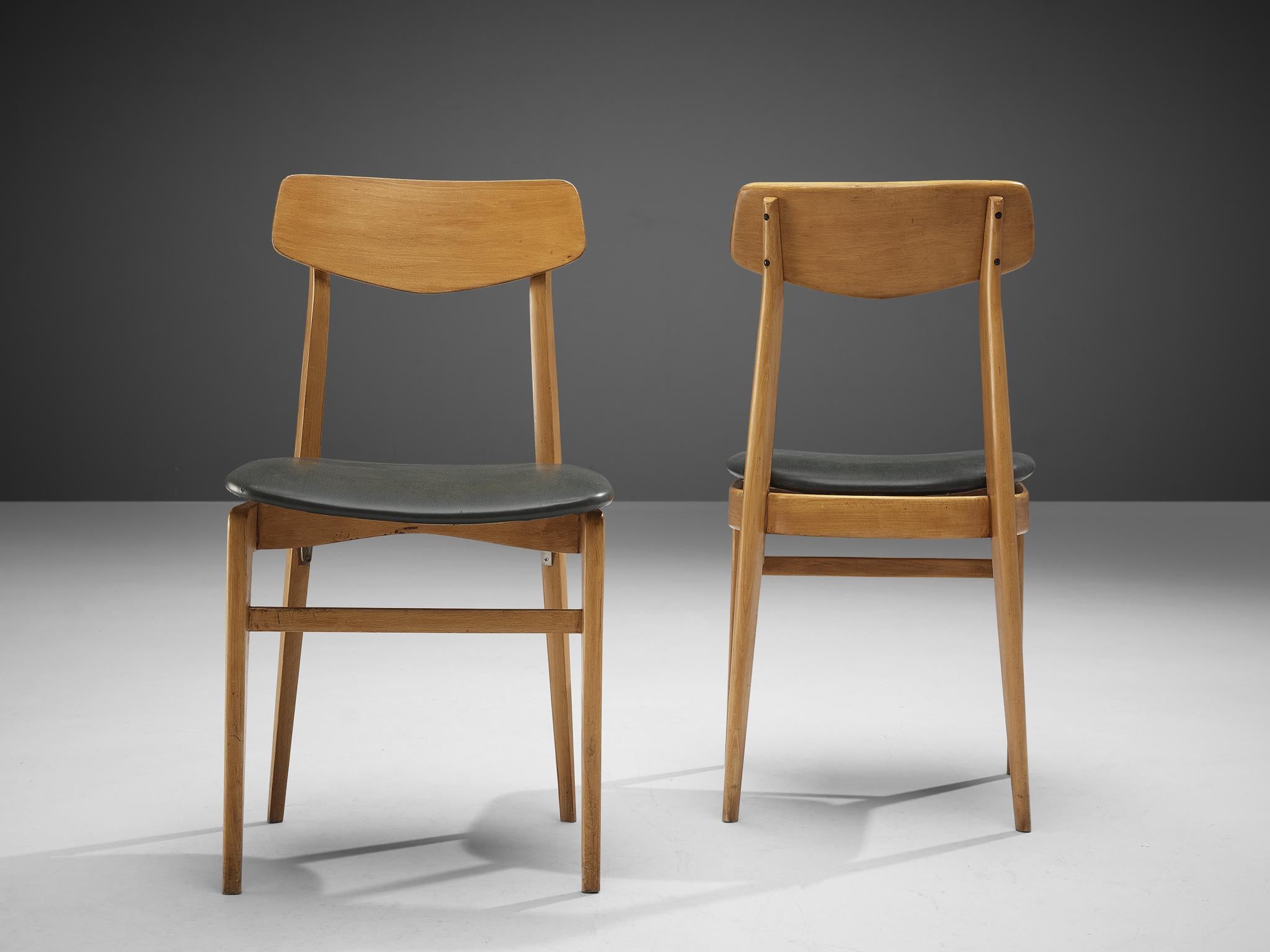 Pair of dining chairs, beech, leatherette, Denmark, 1960s 

Highly elegant chairs that would appear gracefully around one's dining or conference table. The sharp sculpted backrest is supported by two pillar legs that develop to the bottom in a