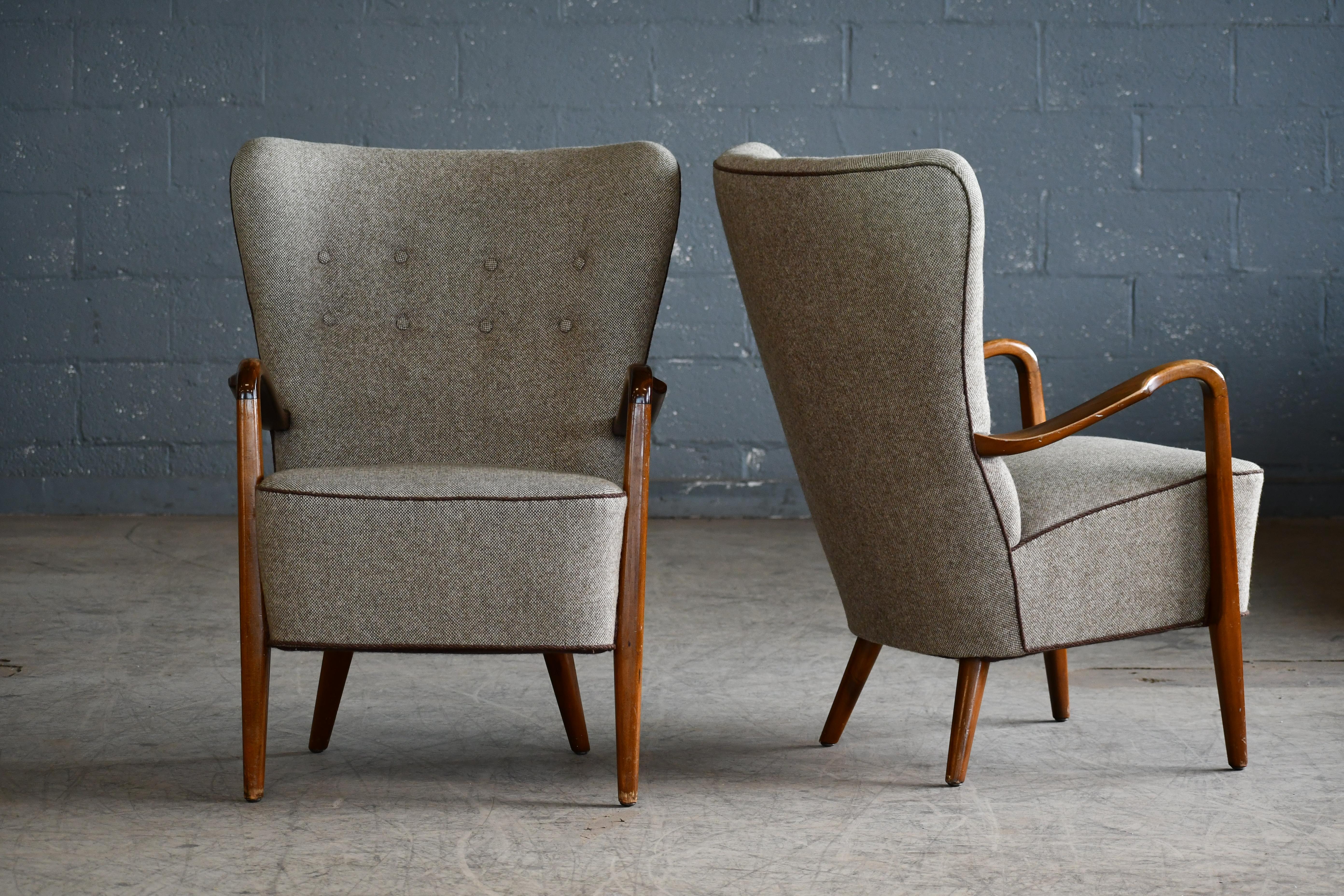 Very stylish armchairs with open armrests attributed to Alfred Christensen and Slagelse Mobelvaer made around 1950 Armrests made of varnished beech and re-upholstered at a later point in a wool fabric that is in good condition showing only minimal