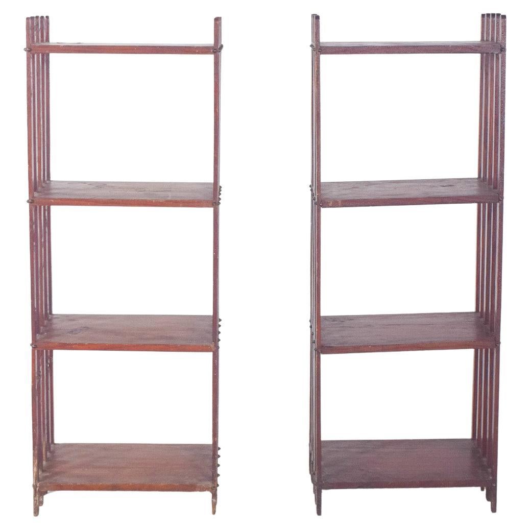 Paire d'étagères à structure ouverte. De conception fonctionnelle, ils sont constitués de quatre étagères horizontales soutenues par des colonnes verticales formées par des bandes disposées en séquence, révélant une légèreté visuelle et une