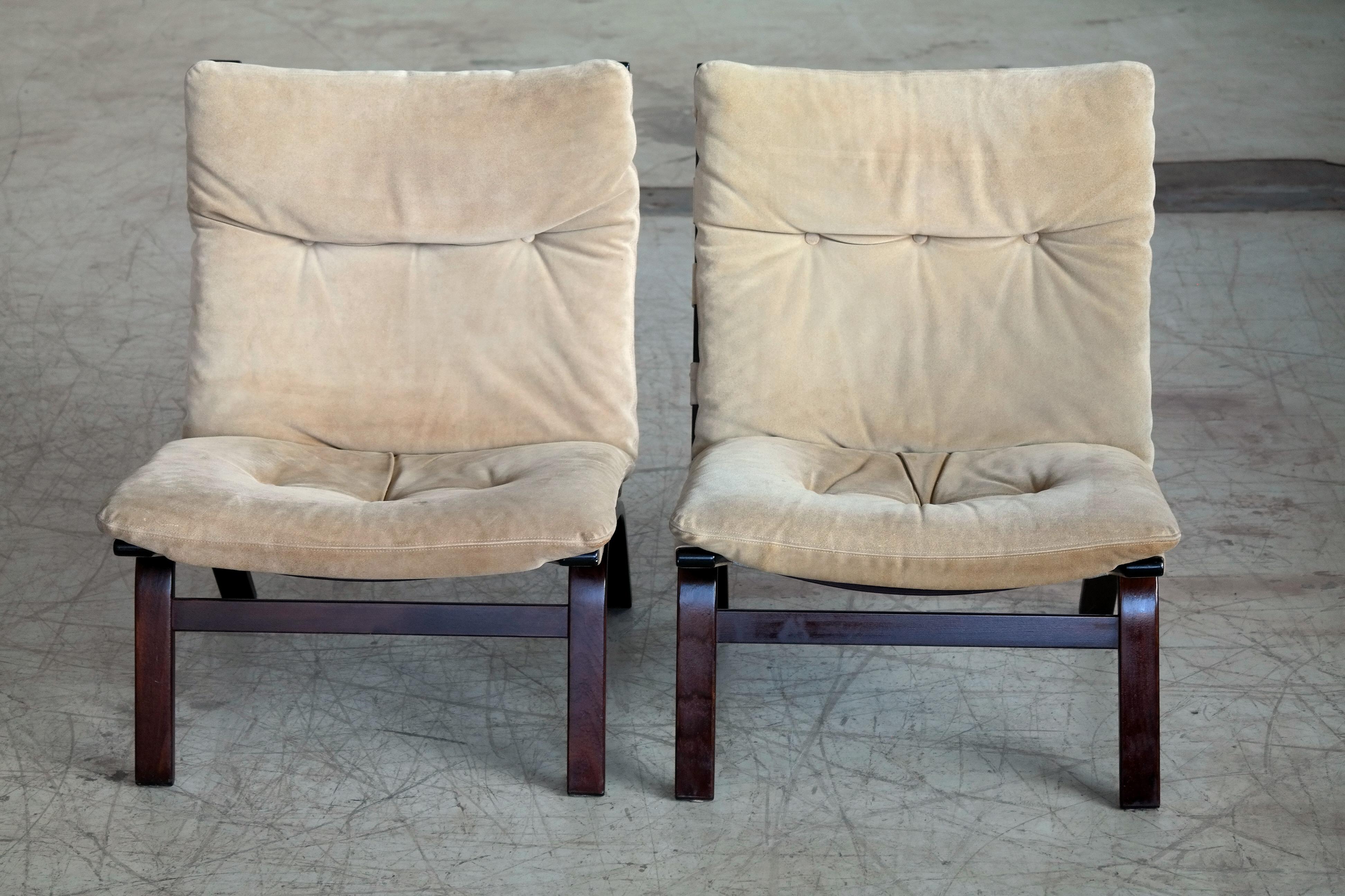 Beautiful pair of easy chairs made from bent plywood in the style of Ingmar Relling's Siesta chairs. This rare pair is made by Farstrup of Denmark around 1970 and covered in a nice beige or cream colored suede. Nice vintage condition with the suede