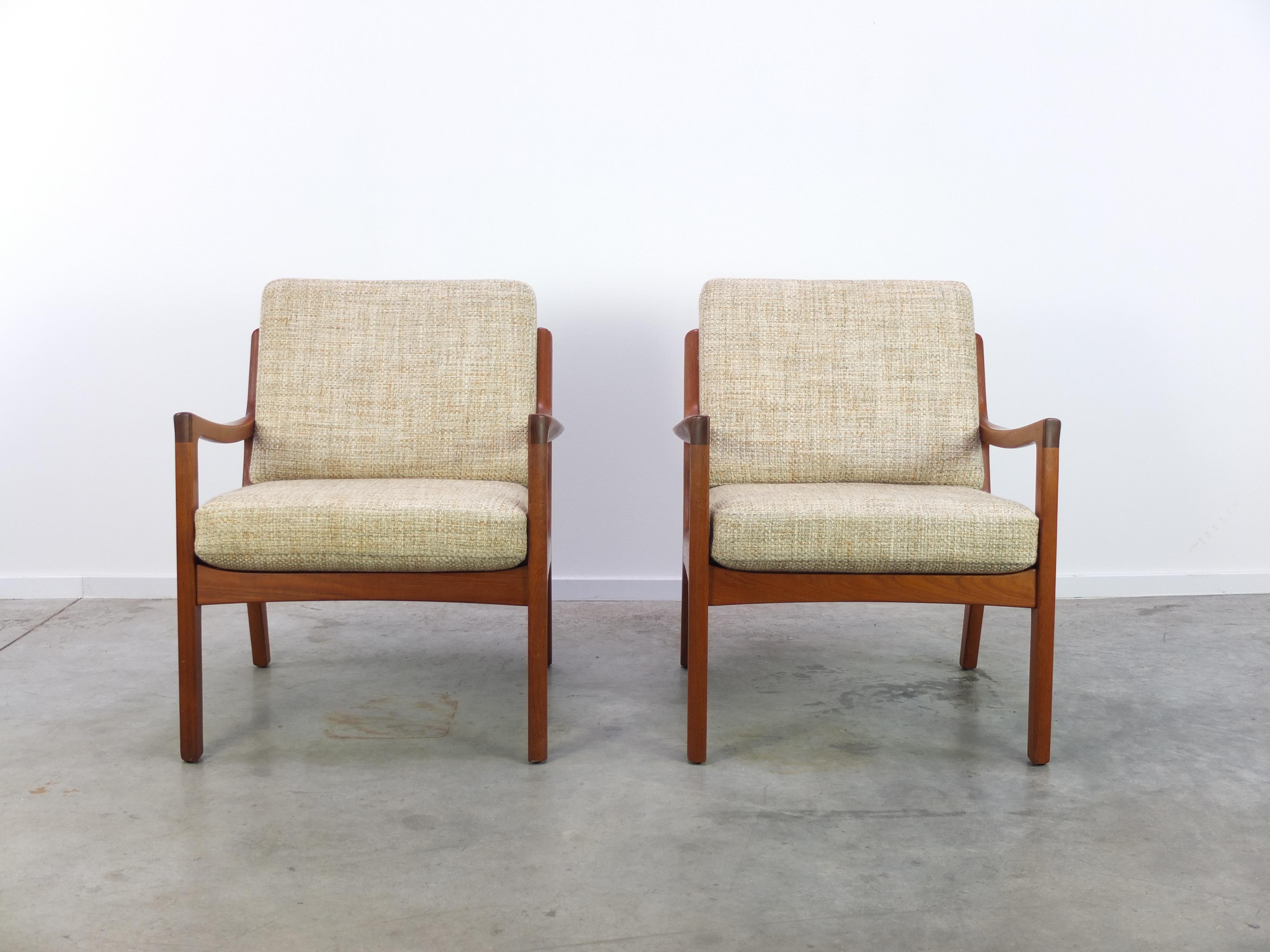 Great pair of easy chairs designed by Ole Wanscher for Cado in 1951. These chairs feature beautiful organic solid teak frames and the original cushions in very good condition. Labeled by the maker.