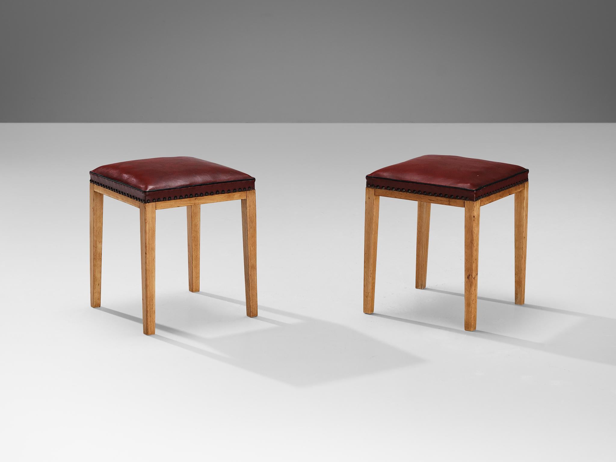 Pair of stools or ottomans, faux leather, beech, brass, Denmark, 1940s

These elegant Scandinavian Modern stools are characterized by a simple construction, showcasing clean lines and distinct angular forms. The seat is crafted using leatherette in