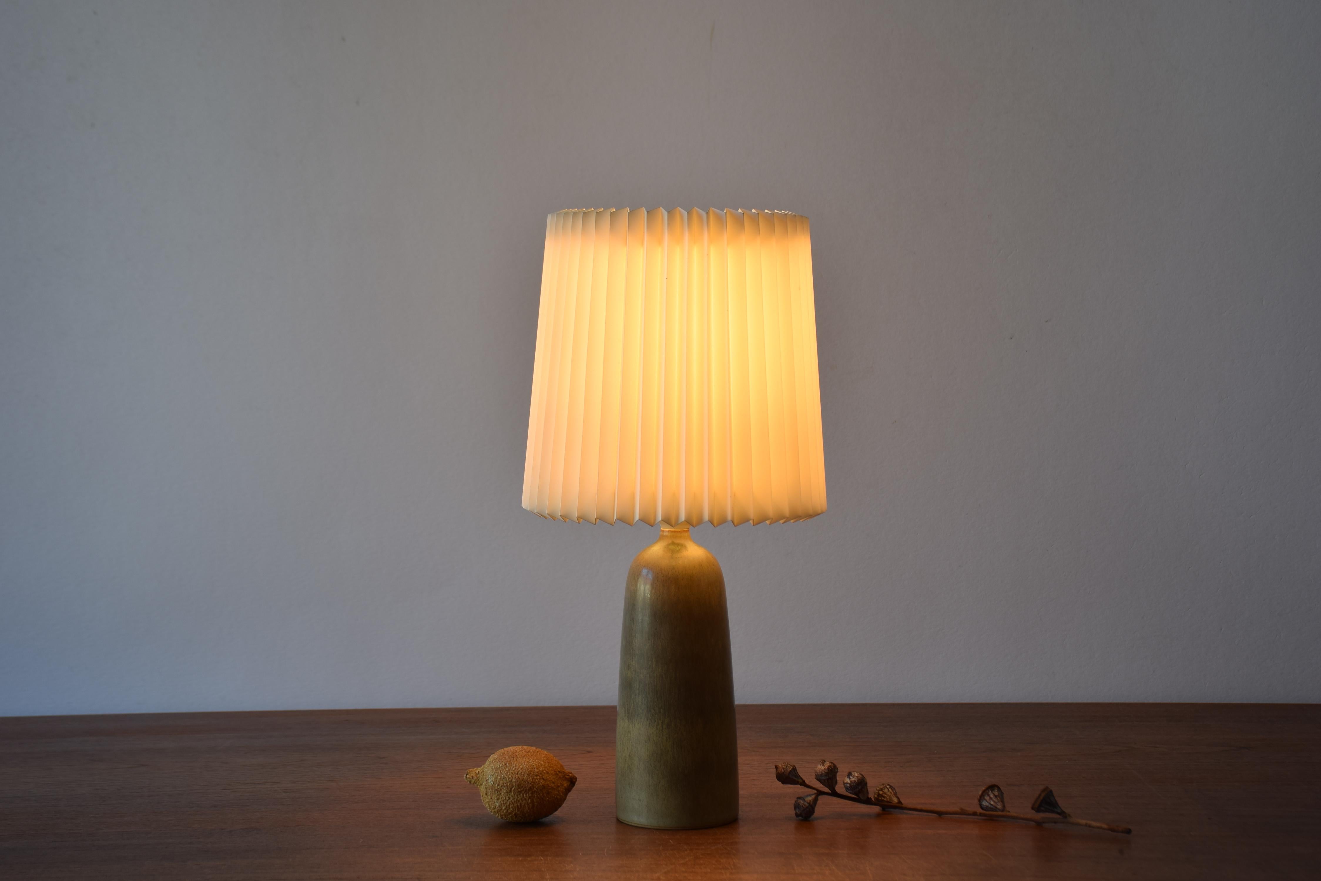 Small ceramic table lamp from Palshus Stentøj, Denmark, made circa 1960s. The lamp comes with a Classic vintage pleated lampshade from Le Klint.

The lampbase was designed by Per Linnemann-Schmidt and has a delicate haresfur glaze in brown shades