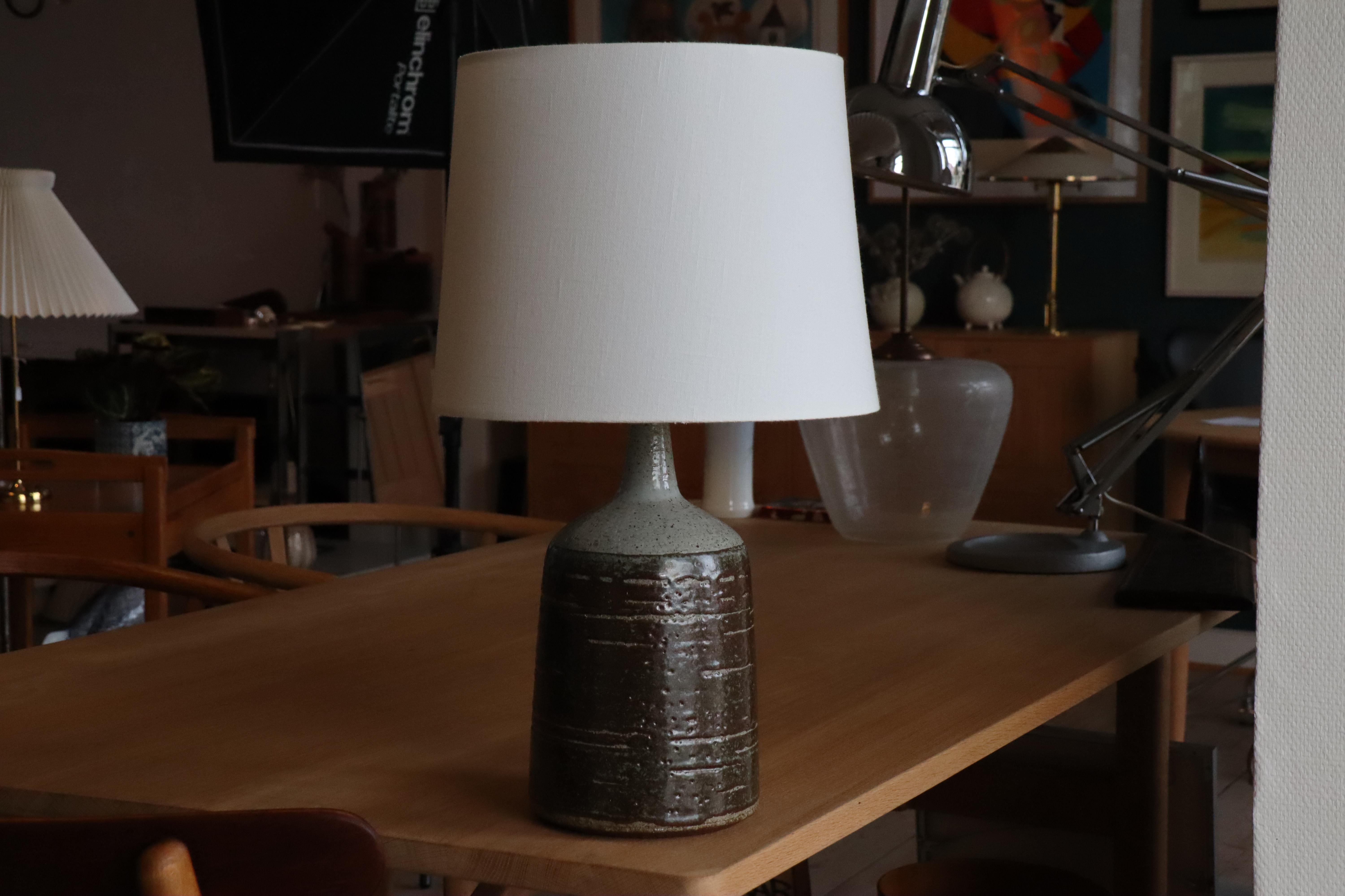 Large mid-century conical shaped table lamp made by Danish Palshus Ceramic.
The lamp was designed by Per Lindemann-Schmidt and made in the 1960s.
It is made with chamotte clay which gives a rough and vivid surface. 
The glaze is grey and