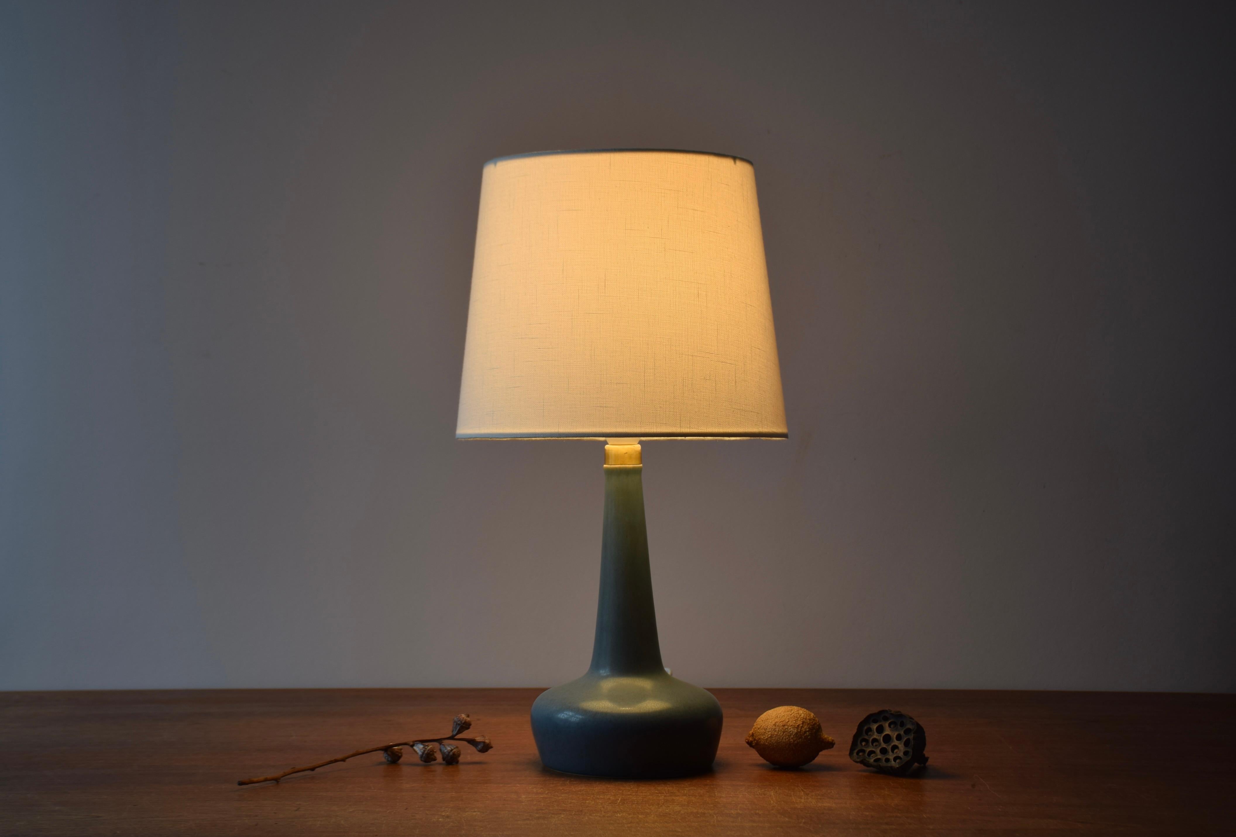 Mid-century Danish Palshus / Le Klint table lamp with dusted blue haresfur glaze contrasted by a top made from brass.

The lamp is designed by Esben Klint and made at the Danish ceramic studio Palshus for the Danish lamp manufacturer Le Klint. Made