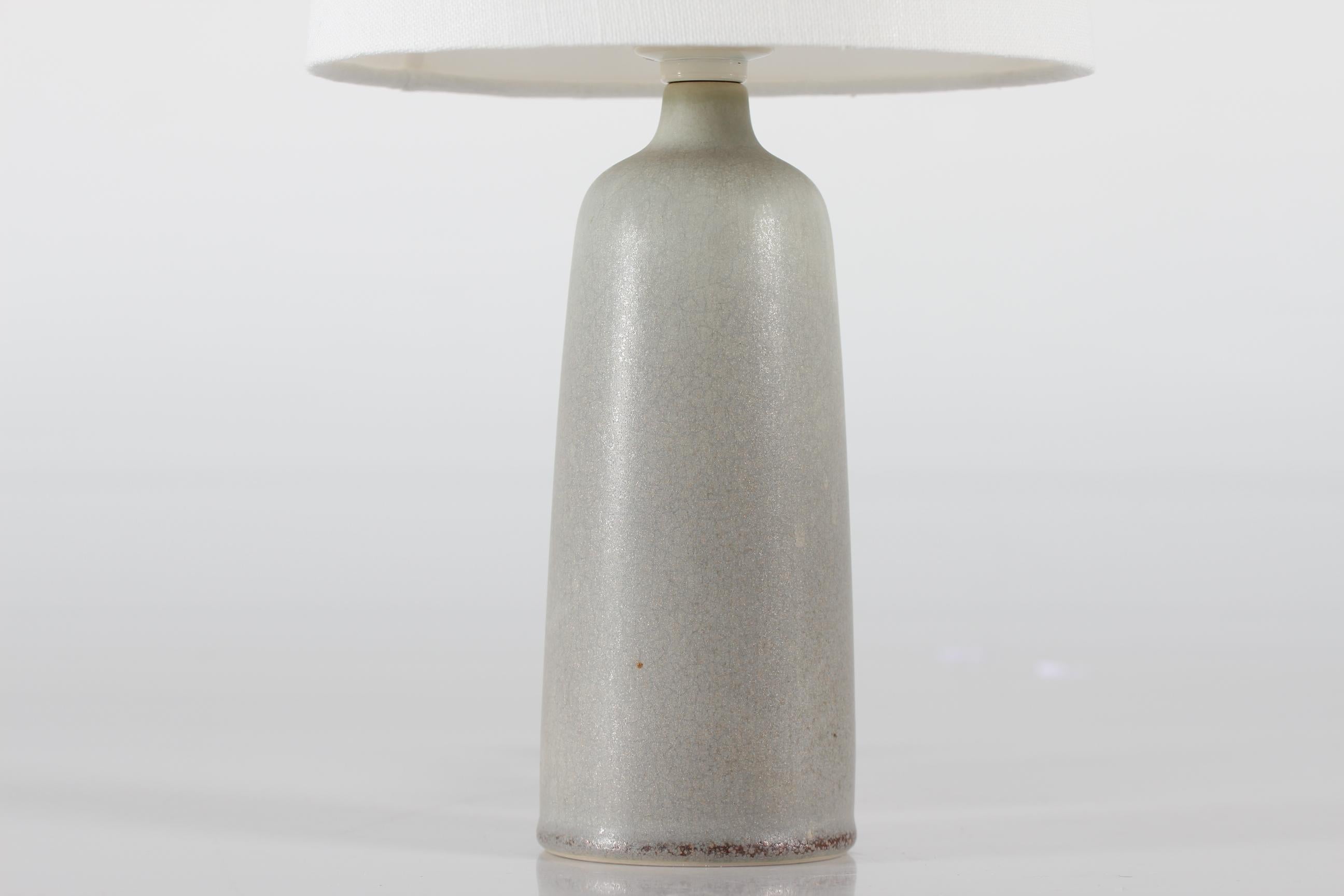 Small Palshus table- and bedside lamp with grey haresfur glaze designed by Per Linnemann-Schmidt. Made in in Denmark in the 1960s

Marked: Palshus + PLS for Per Linnemann-Schmidt + Denmark + DL16

Included is a new lampshade designed and made in