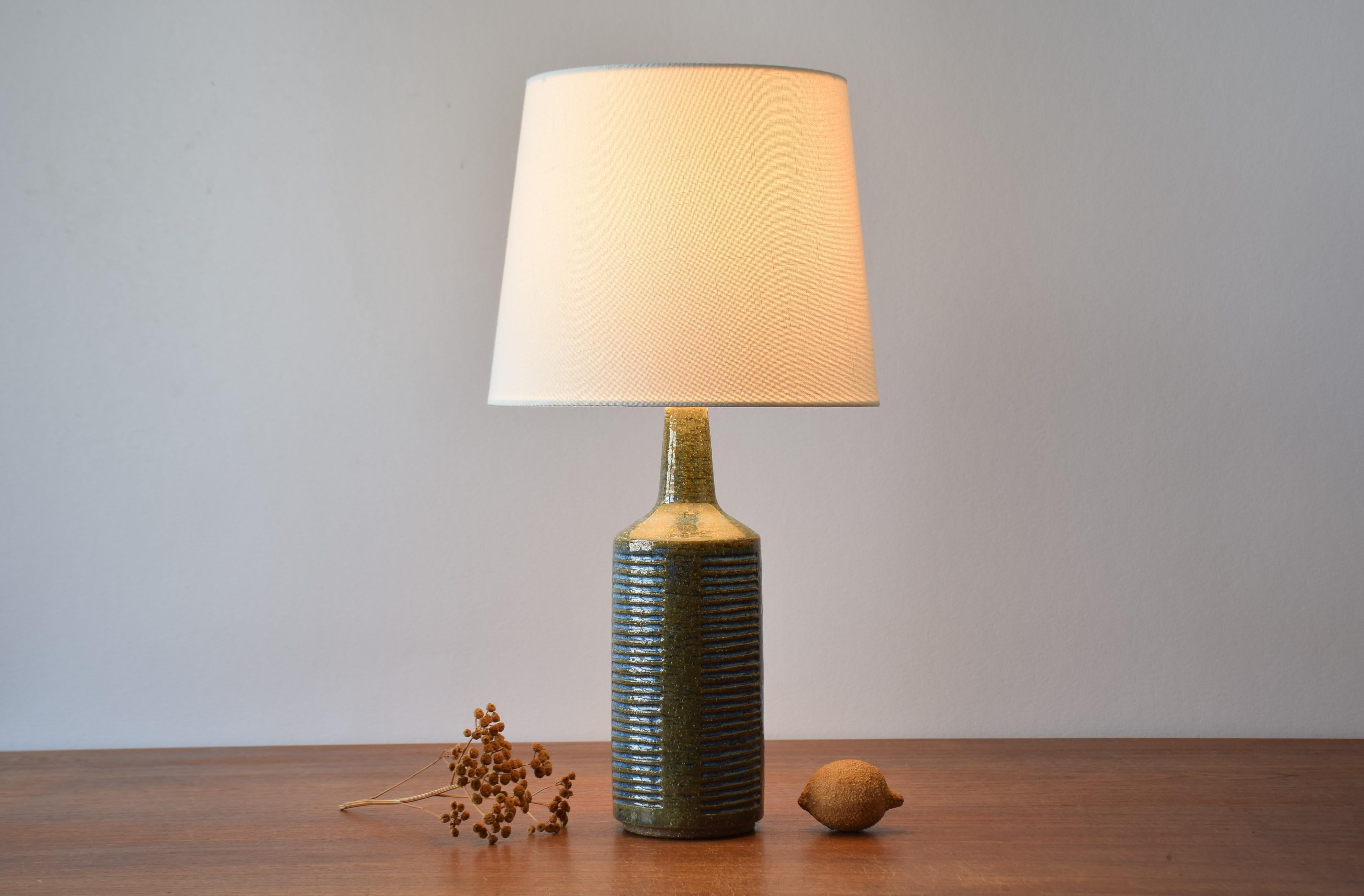 Midcentury table lamp from Danish Palshus including lampshade.
The lamp was designed by Per Linnemann-Schmidt and made circa 1960s.
It is made with chamotte clay which gives a rough and vivid surface. The glaze is moss green with a brigt blue in