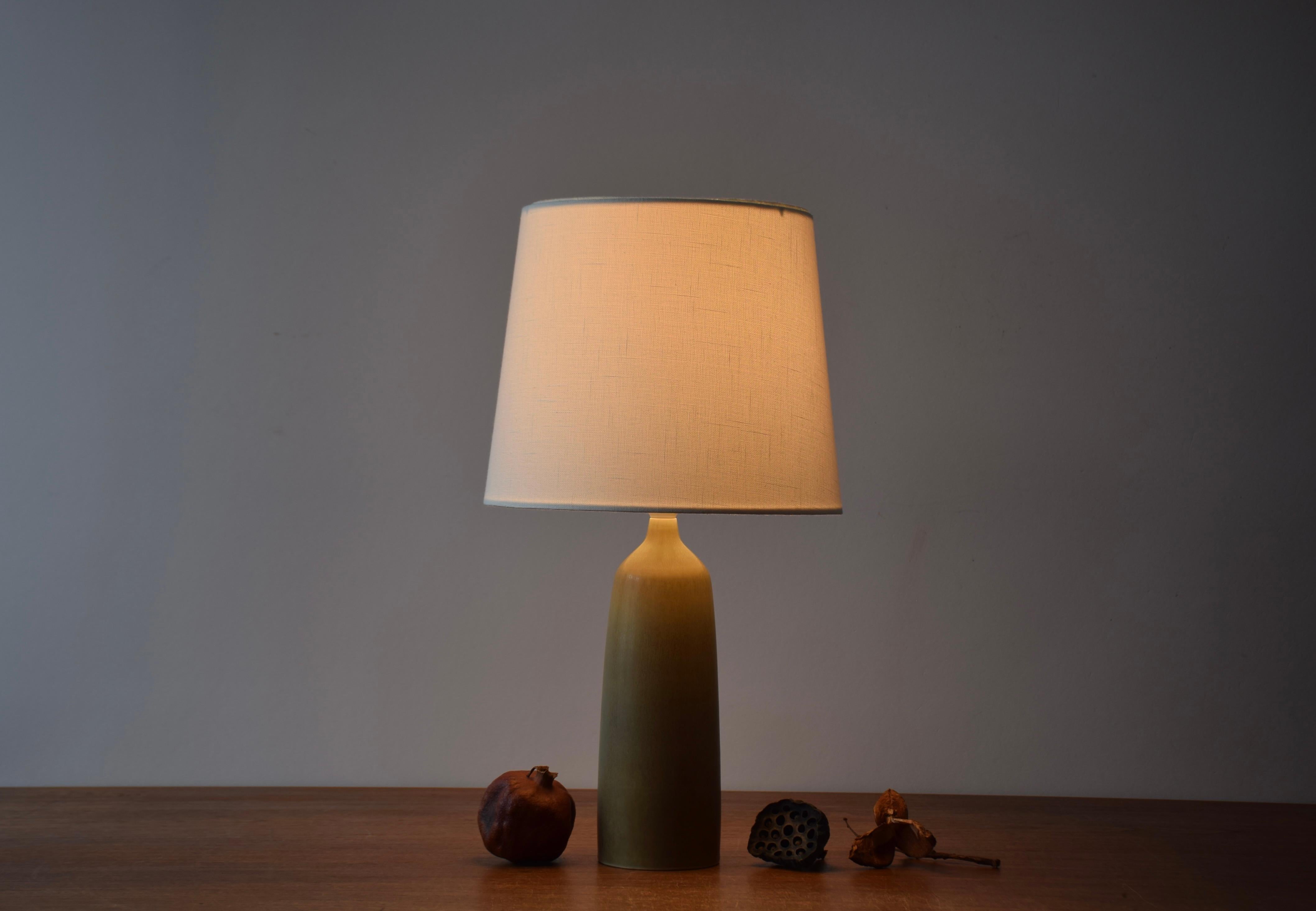 Midcentury table lamp from the Danish ceramic workshop Palshus.  
The lamp was designed by Per Linnemann-Schmidt and manufactured circa 1950s.

The lamp features a olive green haresfur glaze on an elegant shape.

Included is a new lampshade designed