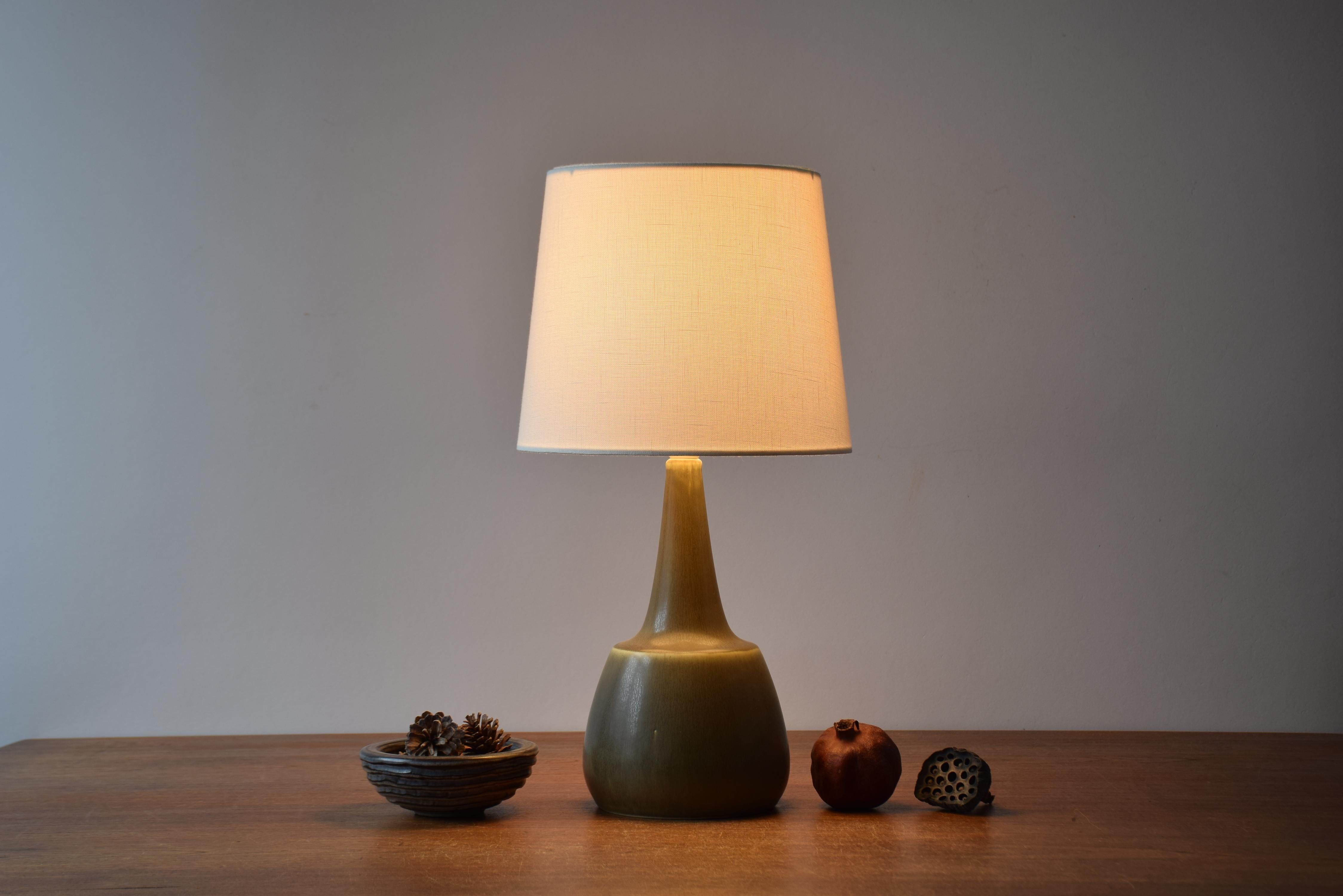 Midcentury table lamp from the Danish ceramic workshop Palshus. 
The lamp was designed by Per Linnemann-Schmidt and manufactured late 1950s or 1960s.

The lamp features an olive green / khaki haresfur glaze.

Included is a new lampshade designed and