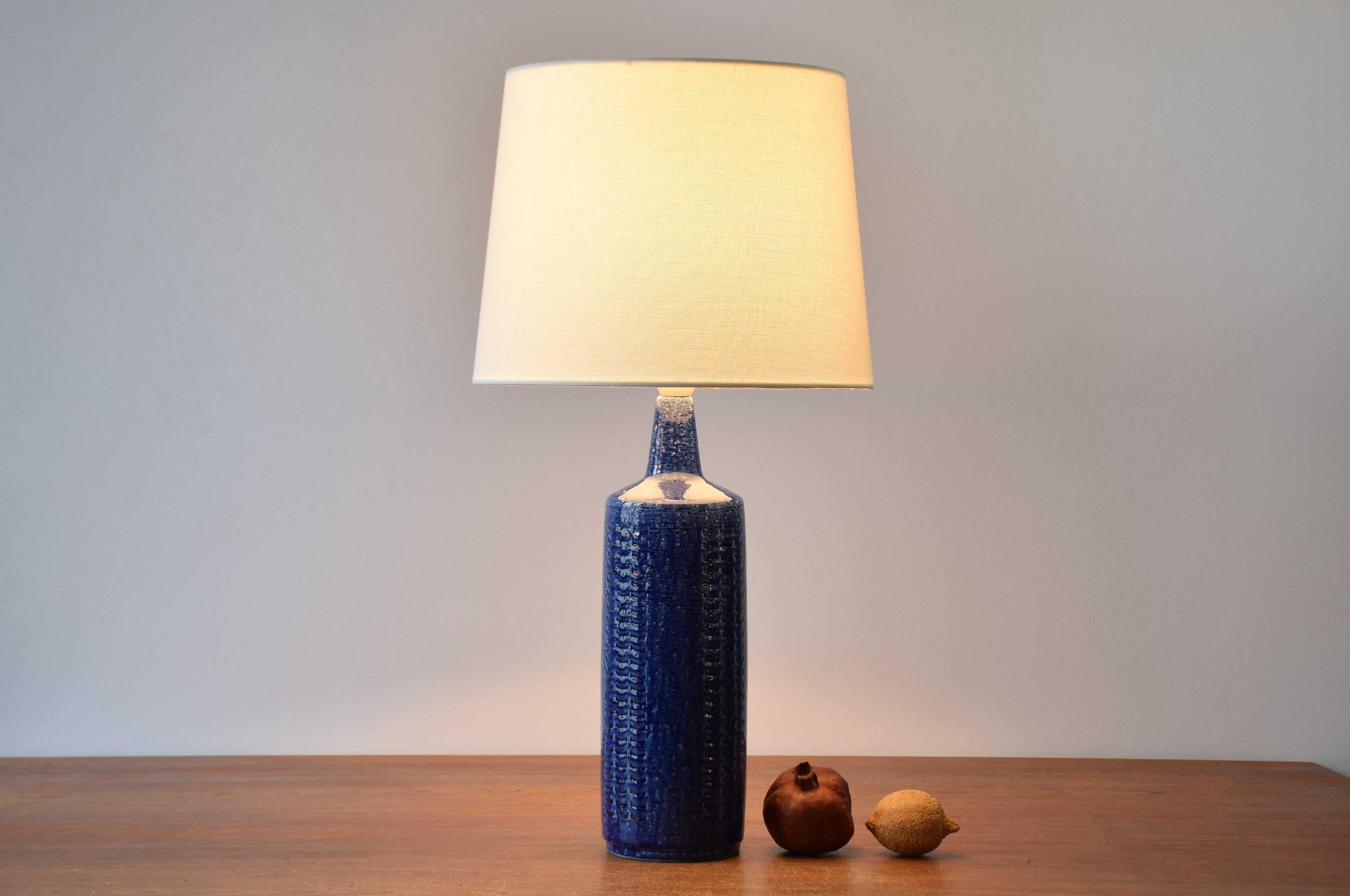 Tall Mid-Century Modern table lamp from the Danish ceramic workshop Palshus.
It was designed by Per Linnemann-Schmidt and made circa 1960s or early 1970s.
It is made with chamotte clay which gives a rough and vivid surface decorated with cobalt