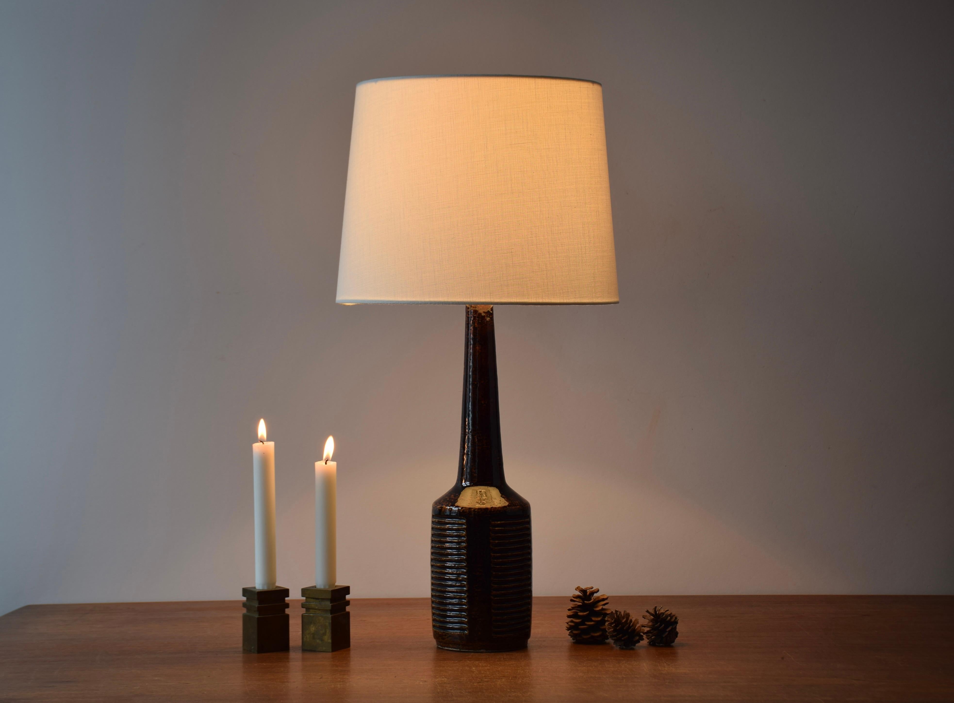 Midcentury tall table lamp from Danish Palshus.
The lamp was designed by Per Linnemann-Schmidt and produced, circa 1960s.
It has a warm dark brown glaze and is made with chamotte clay which gives a rough and vivid surface. It has an imprinted stripe