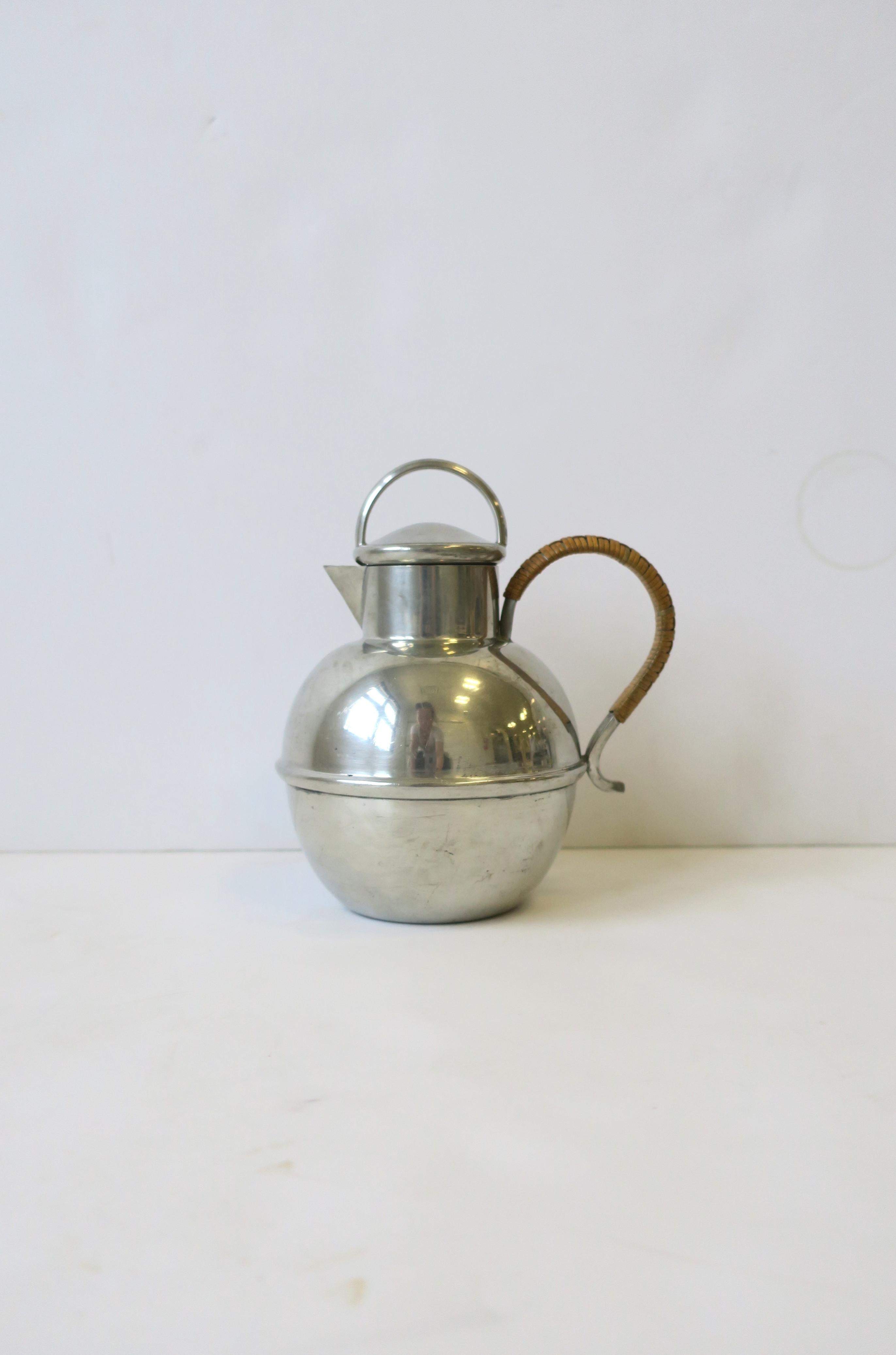 An American silver tone pewter pitcher with wicker handle, circa early-20th century, 1930s, USA (Brooklyn, New York.) Piece was hand-mand in Brooklyn, New York with Danish pewter as marked on bottom. Beautiful as a standalone piece, or for beverages