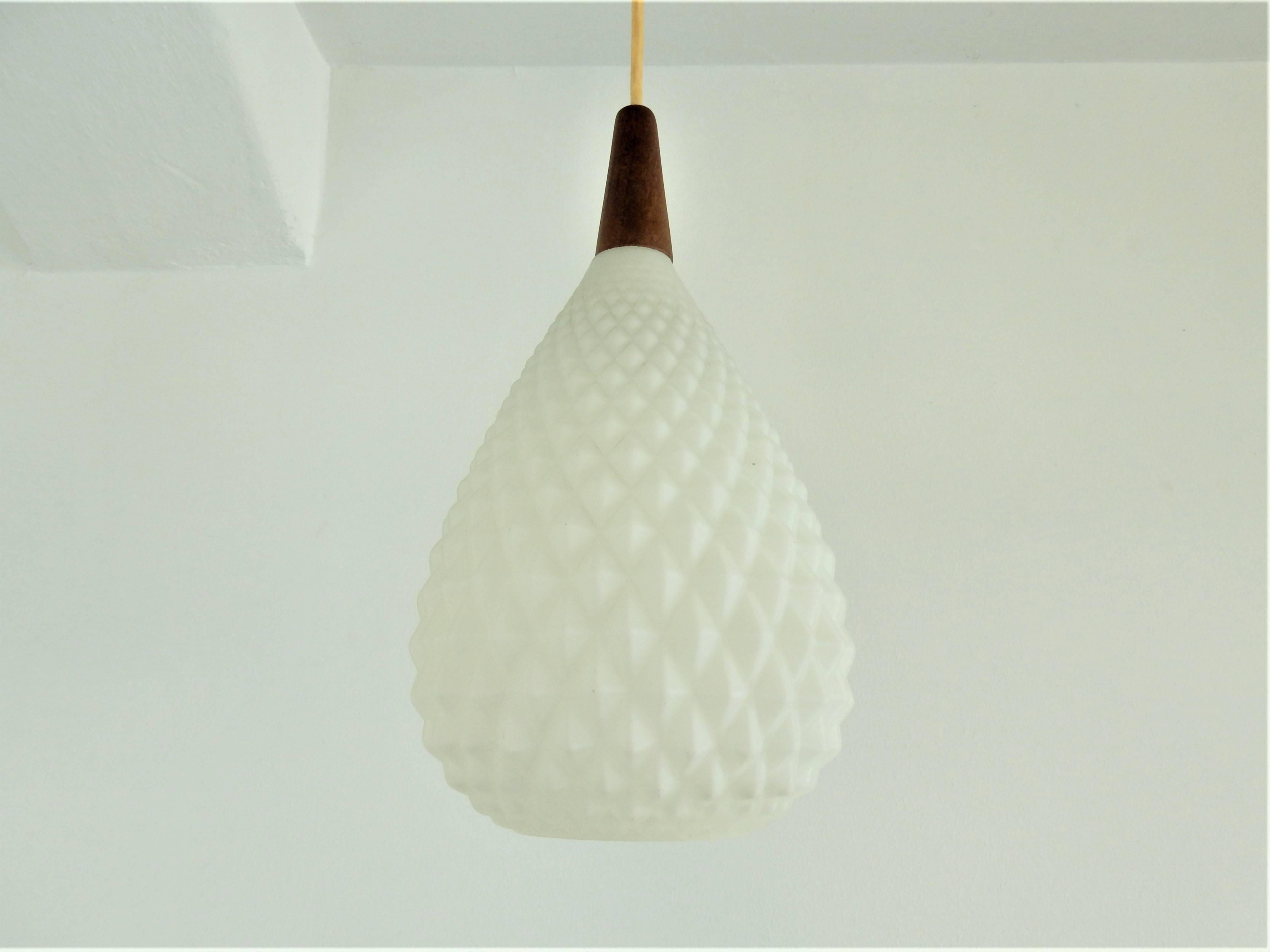 We imported this very nice pinecone shaped pendant lamp from Denmark. It is made of white opaline glass with a teak top. It is in a very good condition with minor signs of age and use.
