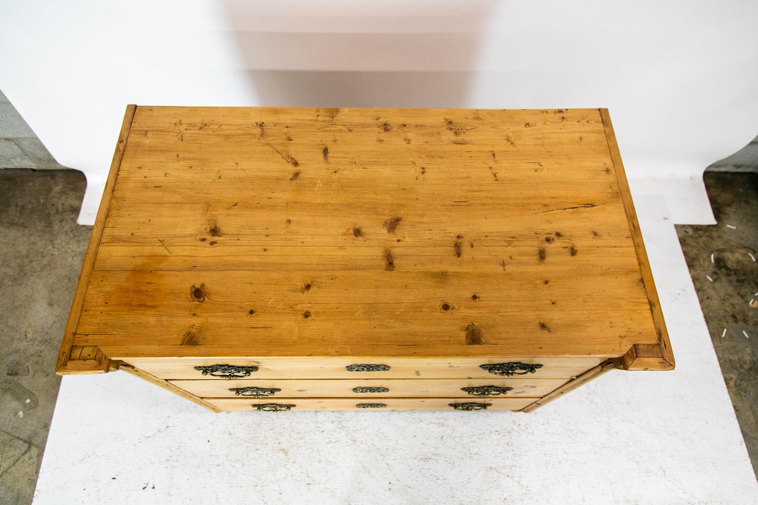 This pine chest has its original large steel locks. The stiles have leaf carvings and shaped moldings terminating in bun feet, which are later. It has a natural wax finish.
 
 